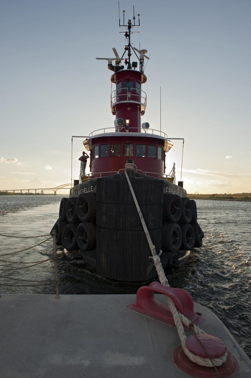 NEW ORLEANS -- A tug boat pulls the Pegasus Barge  carrying the Space Shuttle Program's last external fuel tank, ET-122, from NASA's Michoud Assembly Facility in New Orleans to NASA's Kennedy Space Center in Florida. The tank will travel 900 miles by sea before being offloaded and moved to Kennedy's Vehicle Assembly Building. There it will be integrated to space shuttle Endeavour for the STS-134 mission to the International Space Station.          The tank, which is the largest element of the space shuttle stack, was damaged during Hurricane Katrina in August 2005 and restored to flight configuration by Lockheed Martin Space Systems Company employees. STS-134, targeted to launch Feb. 2011, currently is scheduled to be the last mission in the Space Shuttle Program. Photo credit: NASA/Kim Shiflett
