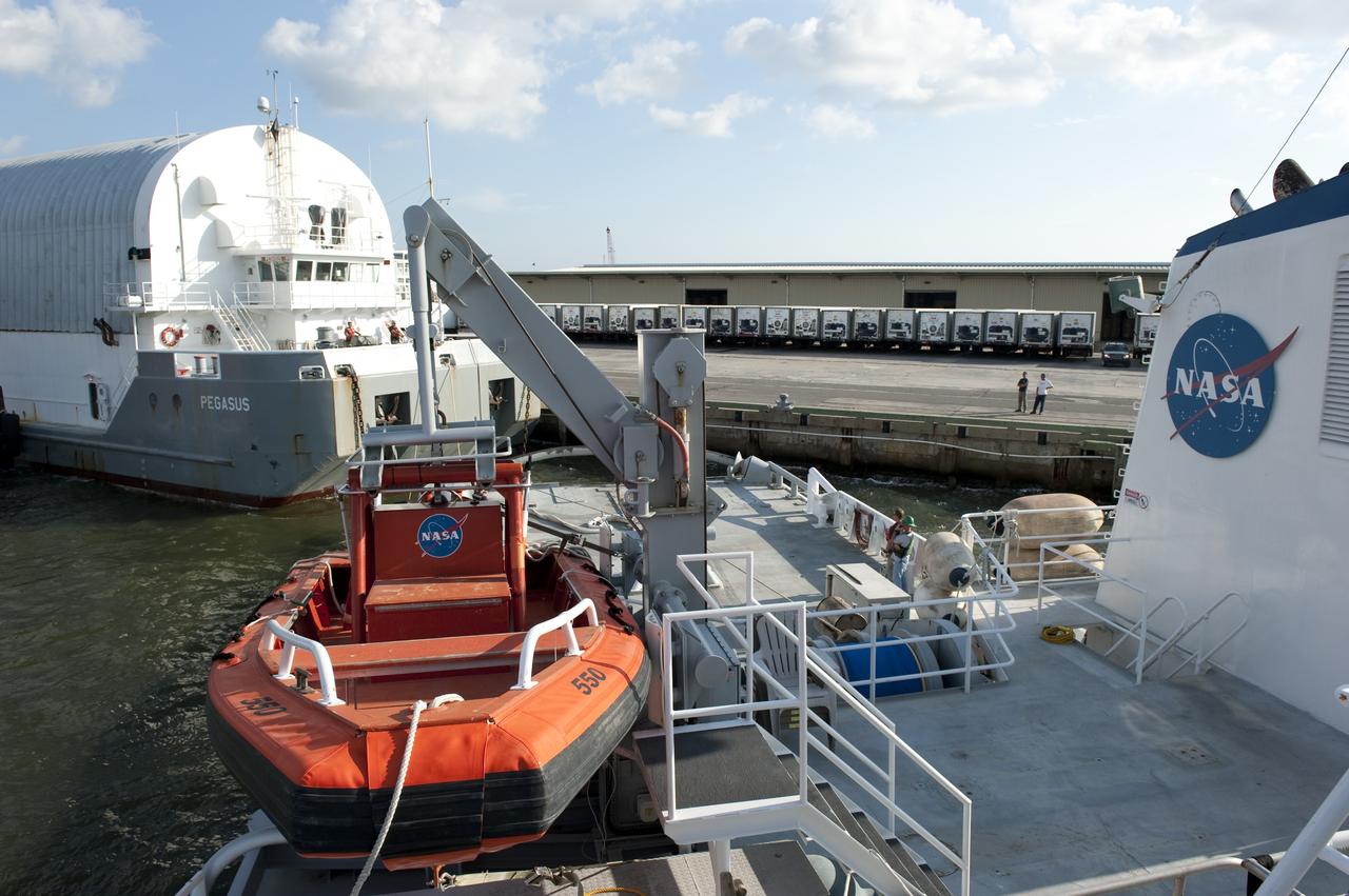 LOUISIANA -- In Gulfport, La., workers connect the Pegasus Barge carrying the Space Shuttle Program's last external fuel tank, ET-122, to Freedom Star, NASA's solid rocket booster retrieval ship. The tank will travel 900 miles by sea to NASA's Kennedy Space Center in Florida before being offloaded and moved to Kennedy's Vehicle Assembly Building. There it will be integrated to space shuttle Endeavour for the STS-134 mission to the International Space Station.            The tank, which is the largest element of the space shuttle stack, was damaged during Hurricane Katrina in August 2005 and restored to flight configuration by Lockheed Martin Space Systems Company employees. STS-134, targeted to launch Feb. 2011, currently is scheduled to be the last mission in the Space Shuttle Program. Photo credit: NASA/Kim Shiflett