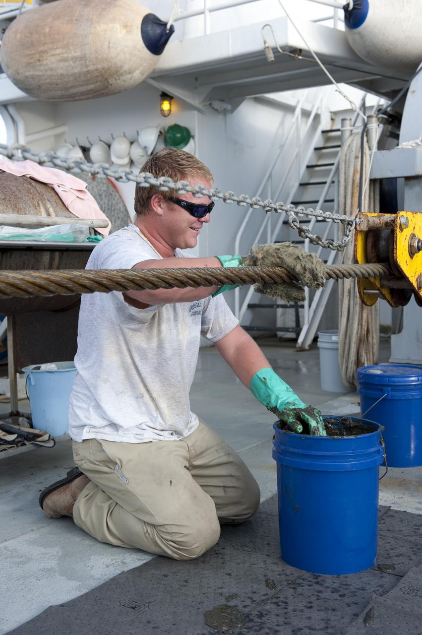 CAPE CANAVERAL, Fla. -- A deckhand on Freedom Star, one of NASA's solid rocket booster retrieval ships, keeps the ship in good repair as it pulls the Pegasus Barge carrying the Space Shuttle Program's last external fuel tank, ET-122. The tank will travel 900 miles by sea to NASA's Kennedy Space Center in Florida before being offloaded and moved to Kennedy's Vehicle Assembly Building. There it will be integrated to space shuttle Endeavour for the STS-134 mission to the International Space Station.        The tank, which is the largest element of the space shuttle stack, was damaged during Hurricane Katrina in August 2005 and restored to flight configuration by Lockheed Martin Space Systems Company employees. STS-134, targeted to launch Feb. 2011, currently is scheduled to be the last mission in the Space Shuttle Program. Photo credit: NASA/Kim Shiflett