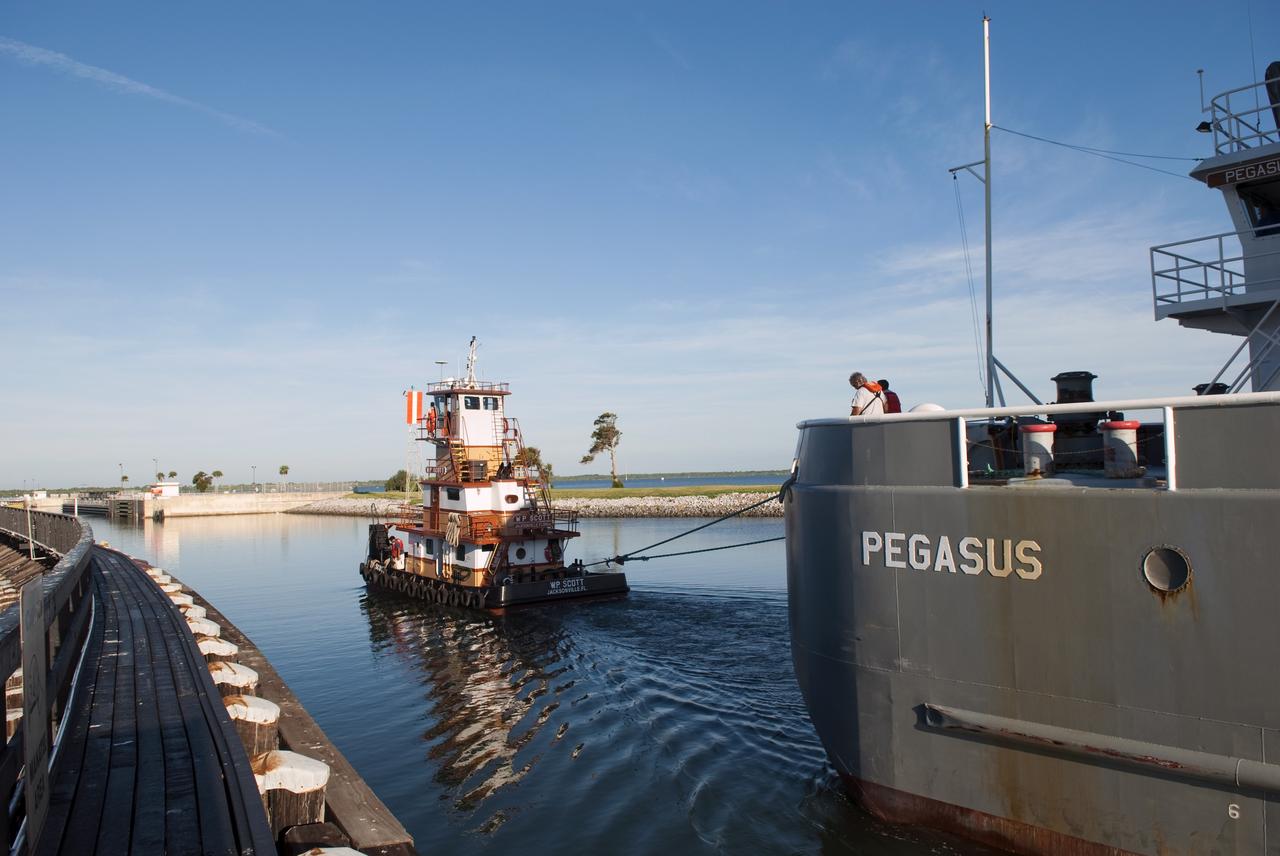 CAPE CANAVERAL, Fla. -- A tugboat pulls the Pegasus Barge carrying the Space Shuttle Program's last external fuel tank, ET-122, toward NASA's Kennedy Space Center in Florida. The tank traveled 900 miles by sea from NASA's Michoud Assembly Facility in New Orleans. After reaching the Turn Basin at Kennedy, the tank will be offloaded and moved to the Vehicle Assembly Building where it eventually will be attached to space shuttle Endeavour for the STS-134 mission to the International Space Station. STS-134, targeted to launch in Feb. 2011, currently is scheduled to be the last mission in the Space Shuttle Program.           The tank, which is the largest element of the space shuttle stack, was damaged during Hurricane Katrina in August 2005 and restored to flight configuration by Lockheed Martin Space Systems Company employees. Photo credit: NASA/Jim Grossmann