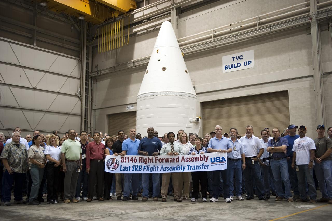 CAPE CANAVERAL, Fla. -- At NASA's Kennedy Space Center in Florida, United Space Alliance employees gather and hold up a banner at a ceremony being held to commemorate the move from Kennedy's Assembly Refurbishment Facility (ARF) to the Vehicle Assembly Building (VAB) of the Space Shuttle Program's final solid rocket booster structural assembly -- the right-hand forward. The move was postponed because of inclement weather. Photo credit: NASA/Kim Shiflett