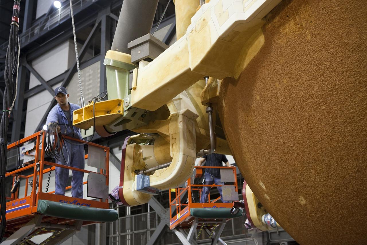 CAPE CANAVERAL, Fla. -- In the Vehicle Assembly Building at NASA's Kennedy Space Center in Florida, workers check the hoist connections on External Fuel Tank-122 as it is lifted toward a test cell.        ET-122, the Space Shuttle Program's last external fuel tank was delivered to Kennedy's Turn Basin from NASA’s Michoud Assembly Facility in New Orleans aboard the Pegasus Barge. After testing, ET-122 eventually will be attached to space shuttle Endeavour for the STS-134 mission to the International Space Station targeted to launch February, 2011. For more information visit: http://www.nasa.gov/mission_pages/shuttle/shuttlemissions/sts134/index.html. Photo credit: NASA/Dimitri Gerondidakis