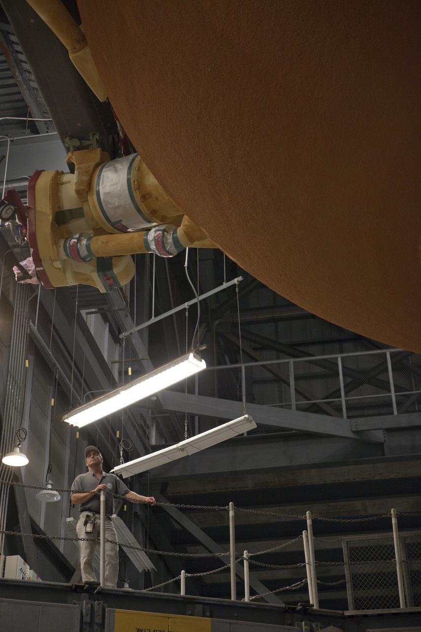 CAPE CANAVERAL, Fla. -- In the Vehicle Assembly Building at NASA's Kennedy Space Center in Florida, a worker checks the progress of External Fuel Tank-122 as it is being lowered into a test stand where it will be checked out before launch.        ET-122, the Space Shuttle Program's last external fuel tank was delivered to Kennedy's Turn Basin from NASA’s Michoud Assembly Facility in New Orleans aboard the Pegasus Barge. After testing, ET-122 eventually will be attached to space shuttle Endeavour for the STS-134 mission to the International Space Station targeted to launch February, 2011. For more information visit: http://www.nasa.gov/mission_pages/shuttle/shuttlemissions/sts134/index.html. Photo credit: NASA/Dimitri Gerondidakis