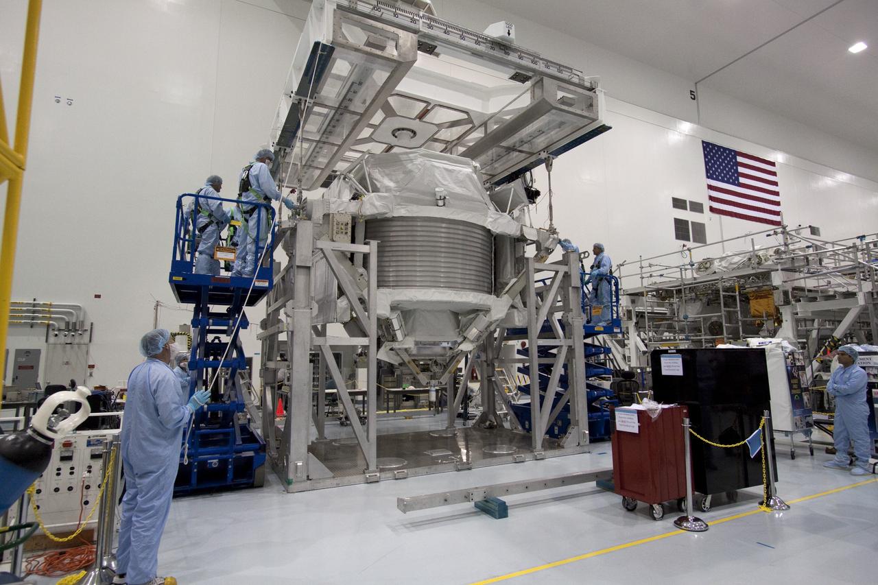 CAPE CANAVERAL, Fla. -- In the Space Station Processing Facility at NASA's Kennedy Space Center in Florida, technicians begin the process of attaching an overhead hoist to the Alpha Magnetic Spectrometer (AMS) for its move to a rotation stand to begin processing for flight.      AMS, a state-of-the-art particle physics detector, is designed to operate as an external experiment on the International Space Station. It will use the unique environment of space to study the universe and its origin by searching for dark matter. AMS will fly to the station aboard space shuttle Endeavour's STS-134 mission targeted to launch February, 2011. For more information visit: http://www.nasa.gov/mission_pages/shuttle/shuttlemissions/sts134/index.html. Photo credit: NASA/Jack Pfaller