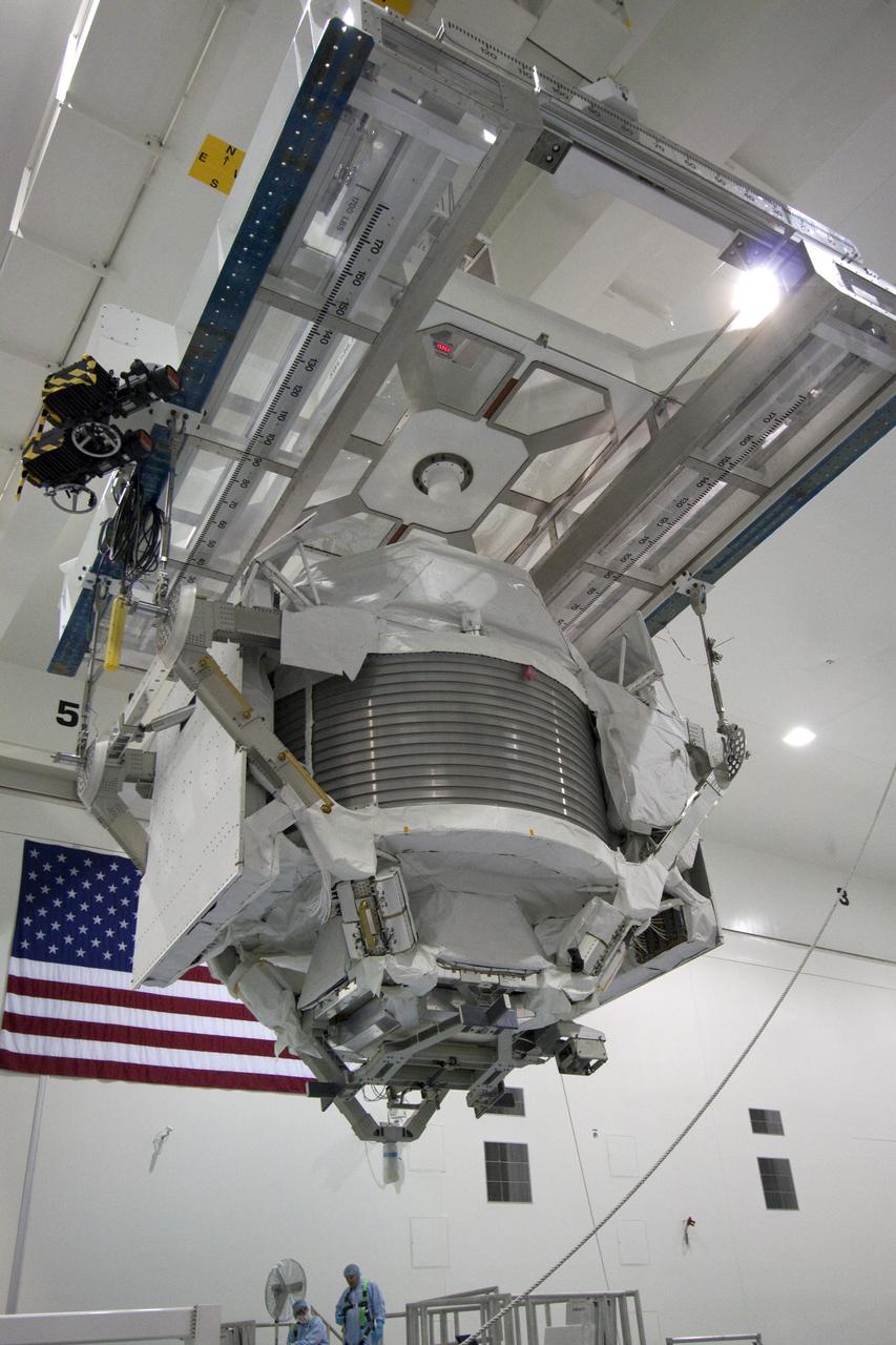 CAPE CANAVERAL, Fla. -- High overhead in the Space Station Processing Facility at NASA's Kennedy Space Center in Florida,  the Alpha Magnetic Spectrometer (AMS) hovers over a rotation stand where it will be tested and processed for launch.    AMS, a state-of-the-art particle physics detector, is designed to operate as an external experiment on the International Space Station. It will use the unique environment of space to study the universe and its origin by searching for dark matter. AMS will fly to the station aboard space shuttle Endeavour's STS-134 mission targeted to launch February, 2011. For more information visit: http://www.nasa.gov/mission_pages/shuttle/shuttlemissions/sts134/index.html. Photo credit: NASA/Jack Pfaller
