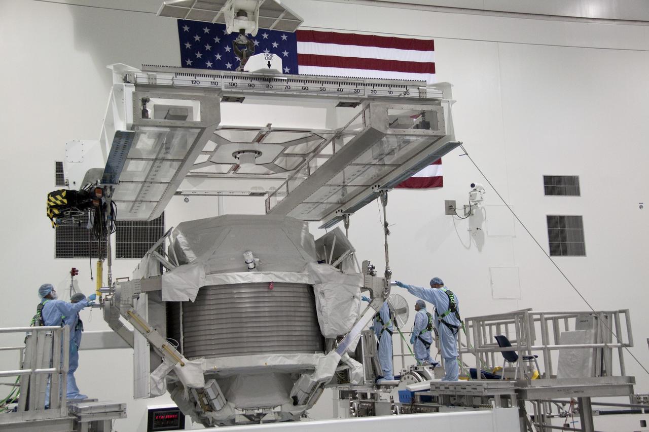 CAPE CANAVERAL, Fla. -- In the Space Station Processing Facility at NASA's Kennedy Space Center in Florida, technicians guide the Alpha Magnetic Spectrometer (AMS) onto a rotation stand where it will be tested and processed for launch.    AMS, a state-of-the-art particle physics detector, is designed to operate as an external experiment on the International Space Station. It will use the unique environment of space to study the universe and its origin by searching for dark matter. AMS will fly to the station aboard space shuttle Endeavour's STS-134 mission targeted to launch February, 2011. For more information visit: http://www.nasa.gov/mission_pages/shuttle/shuttlemissions/sts134/index.html. Photo credit: NASA/Jack Pfaller
