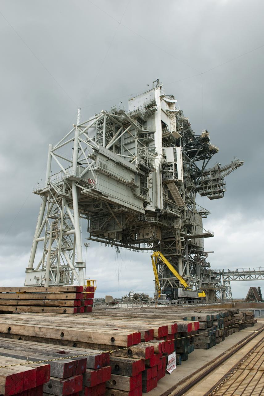CAPE CANAVERAL, Fla. -- At NASA's Kennedy Space Center in Florida, crews are dismantling the rotating service structure (RSS) on Launch Pad 39B. Sand, reinforcing steel and large wooden mats were put down under the RSS to protect the structure's concrete from falling debris during deconstruction.          Starting in 2009, the structure at the pad was no longer needed for NASA's Space Shuttle Program, so it is being restructured for future use. The new design will feature a "clean pad" for rockets to come with their own launcher, making it more versatile for a number of vehicles. The new lightning protection system, consisting of three lightning towers and a wire catenary system will remain. Photo credit: NASA/Jim Grossmann