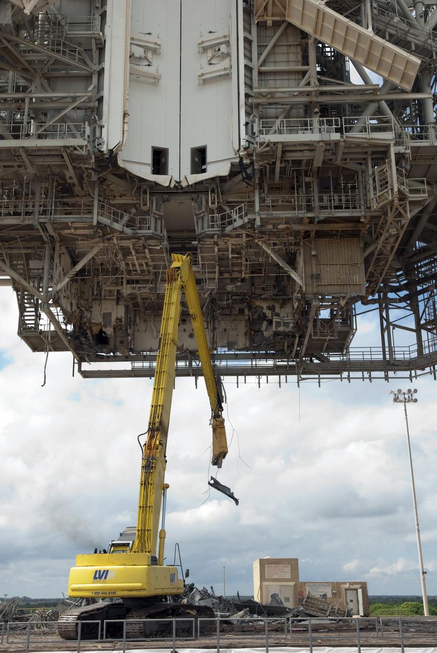 CAPE CANAVERAL, Fla. -- At NASA's Kennedy Space Center in Florida, crews are dismantling the rotating service structure (RSS) on Launch Pad 39B. Sand, reinforcing steel and large wooden mats were put down under the RSS to protect the structure's concrete from falling debris during deconstruction.          Starting in 2009, the structure at the pad was no longer needed for NASA's Space Shuttle Program, so it is being restructured for future use. The new design will feature a "clean pad" for rockets to come with their own launcher, making it more versatile for a number of vehicles. The new lightning protection system, consisting of three lightning towers and a wire catenary system will remain. Photo credit: NASA/Jim Grossmann