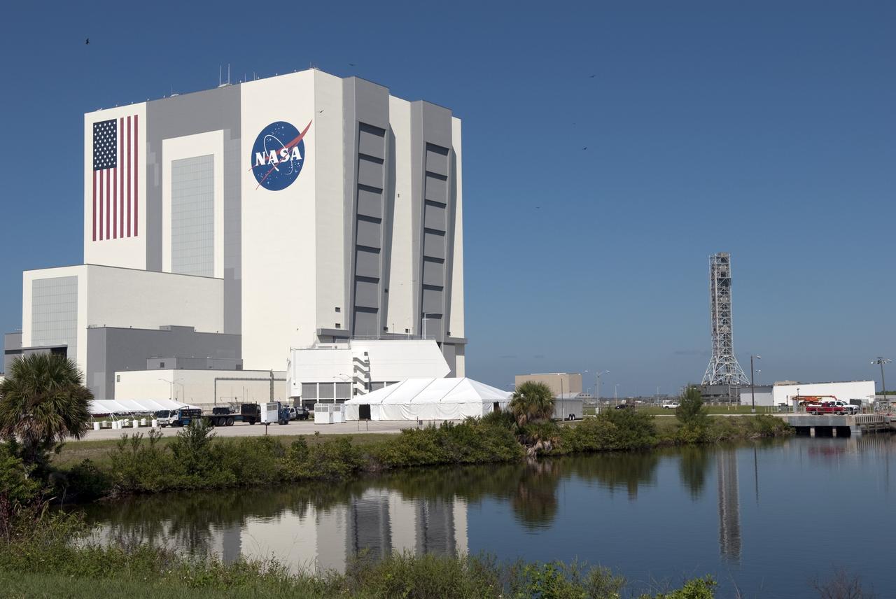 CAPE CANAVERAL, Fla. -- At NASA's Kennedy Space Center in Florida, a crawler-transporter moves NASA's new mobile launcher (ML) support structure from a construction site, north of the Vehicle Assembly Building (left), to the Mobile Launcher east park site. The base of the launcher is lighter than space shuttle mobile launcher platforms so the crawler-transporter can pick up the heavier load of the tower and a taller rocket. Once there, the ML can be outfitted with ground support equipment, such as umbilicals and access arms, for future rocket launches. It took about two years to construct the 355-foot-tall structure, which will support NASA's future human spaceflight program. Photo credit: NASA/Jim Grossmann