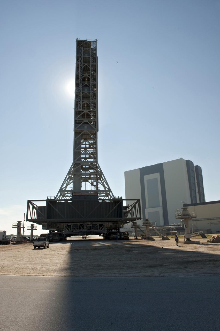 CAPE CANAVERAL, Fla. -- At NASA's Kennedy Space Center in Florida, a crawler-transporter moves NASA's new mobile launcher (ML) support structure from a construction site, north of the Vehicle Assembly Building (background), to the Mobile Launcher east park site. The base of the launcher is lighter than space shuttle mobile launcher platforms so the crawler-transporter can pick up the heavier load of the tower and a taller rocket. Once there, the ML can be outfitted with ground support equipment, such as umbilicals and access arms, for future rocket launches. It took about two years to construct the 355-foot-tall structure, which will support NASA's future human spaceflight program. Photo credit: NASA/Tony Gray