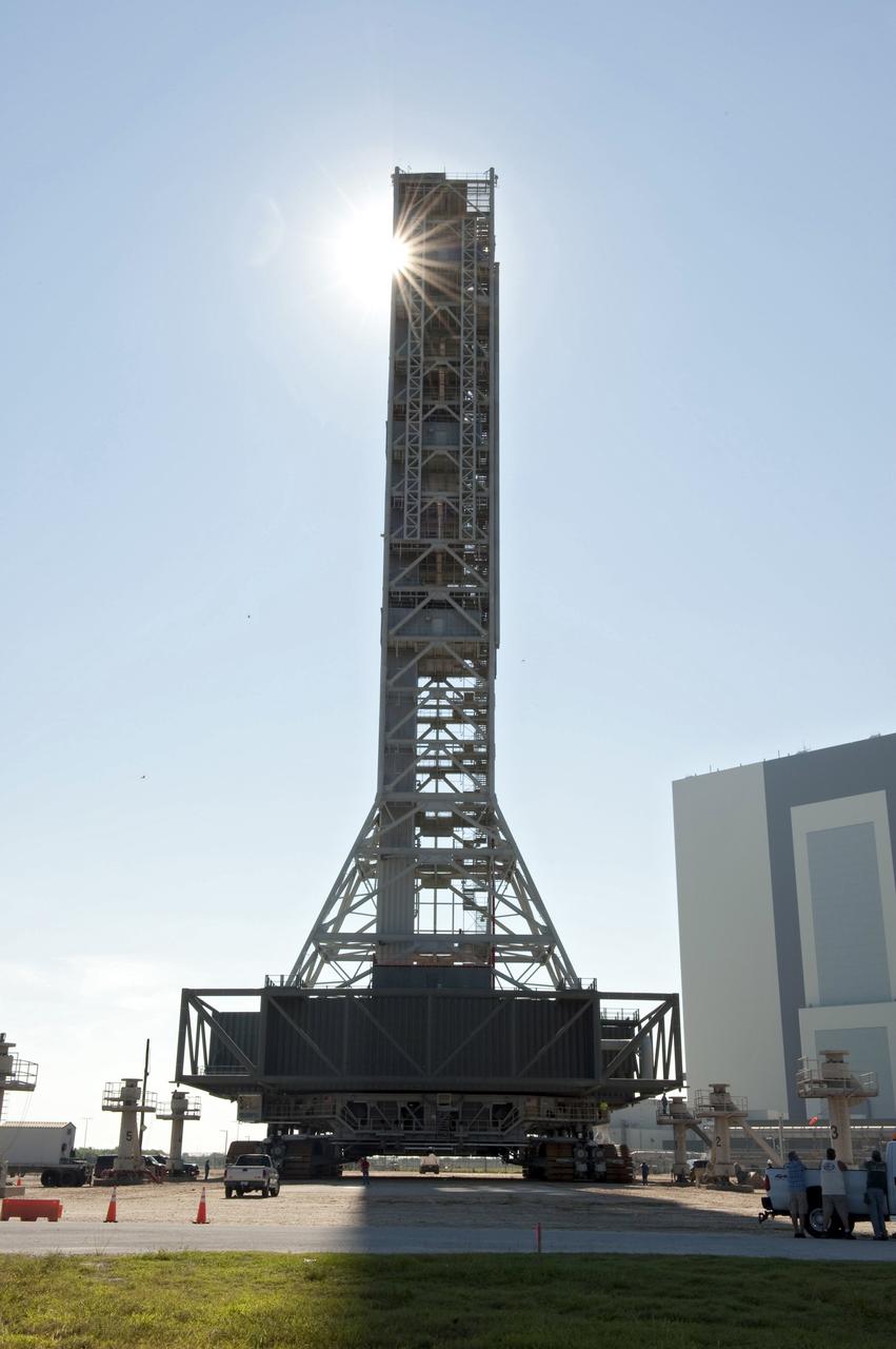 CAPE CANAVERAL, Fla. -- At NASA's Kennedy Space Center in Florida, a crawler-transporter moves NASA's new mobile launcher (ML) support structure from a construction site, north of the Vehicle Assembly Building (right), to the Mobile Launcher east park site. The base of the launcher is lighter than space shuttle mobile launcher platforms so the crawler-transporter can pick up the heavier load of the tower and a taller rocket. Once there, the ML can be outfitted with ground support equipment, such as umbilicals and access arms, for future rocket launches. It took about two years to construct the 355-foot-tall structure, which will support NASA's future human spaceflight program. Photo credit: NASA/Tony Gray