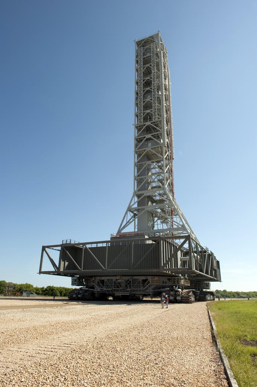 CAPE CANAVERAL, Fla. -- At NASA's Kennedy Space Center in Florida, workers monitor the progress of a crawler-transporter as it moves NASA's new mobile launcher (ML) support structure from a construction site, north of the Vehicle Assembly Building, to the Mobile Launcher east park site. The base of the launcher is lighter than space shuttle mobile launcher platforms so the crawler-transporter can pick up the heavier load of the tower and a taller rocket. Once there, the ML can be outfitted with ground support equipment, such as umbilicals and access arms, for future rocket launches. It took about two years to construct the 355-foot-tall structure, which will support NASA's future human spaceflight program. Photo credit: NASA/Tony Gray
