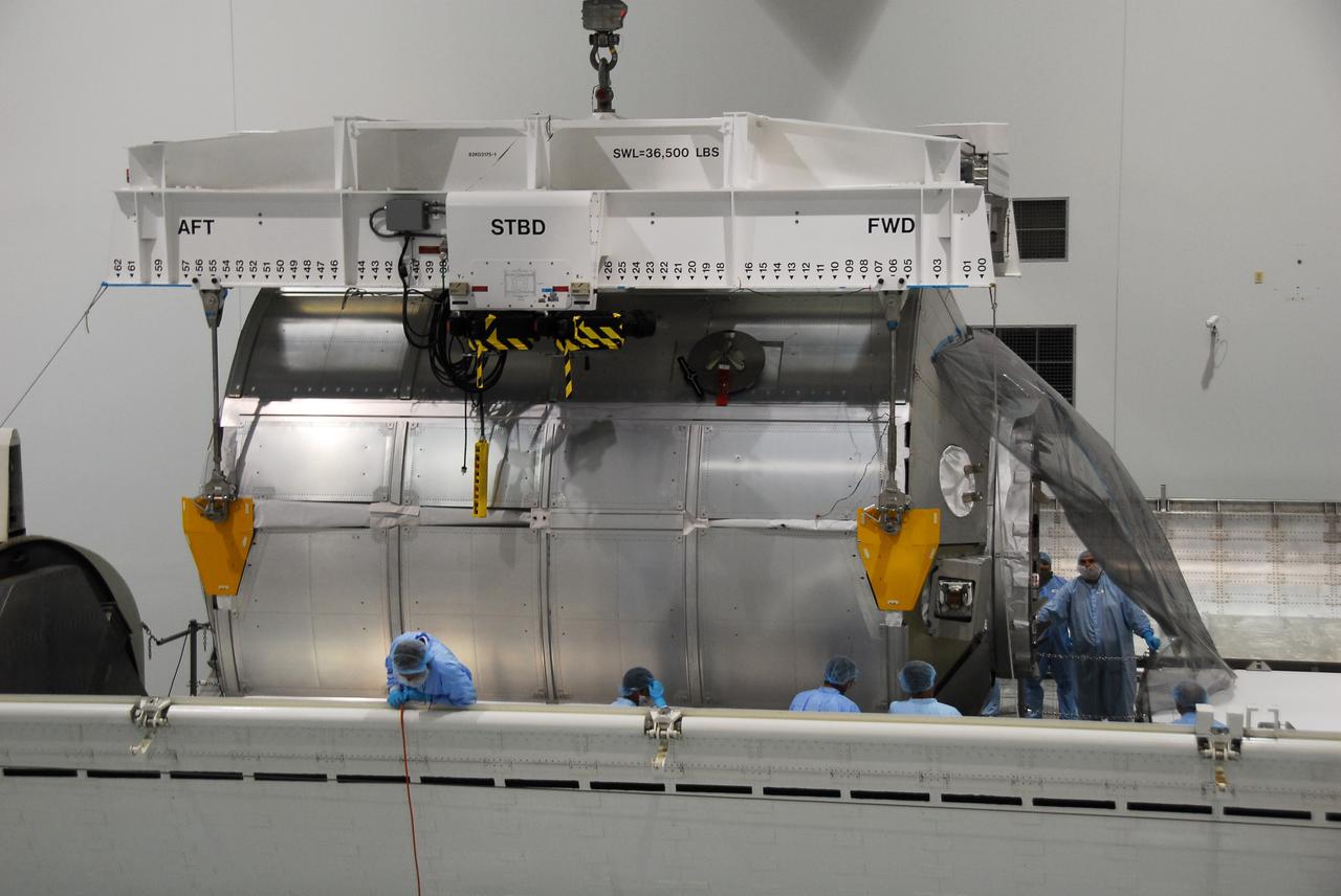 CAPE CANAVERAL, Fla. -- In the Space Station Processing Facility at NASA's Kennedy Space Center in Florida, technicians guide the Permanent Multipurpose Module, or PMM, as an overhead crane lowers it into the payload canister.        The canister will then be transported to Launch Pad 39A and installed into space shuttle Discovery's payload bay. Discovery and its STS-133 crew will deliver the PMM, packed with supplies and critical spare parts, as well as Robonaut 2, the dexterous humanoid astronaut helper, to the International Space Station. Launch is targeted for 4:40 p.m. EDT, Nov. 1. Photo credit: NASA/Cory Huston