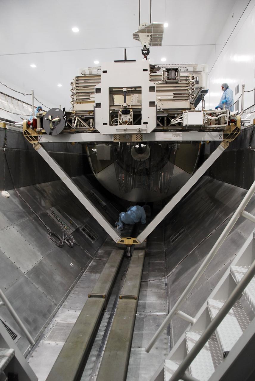 CAPE CANAVERAL, Fla. -- In the Space Station Processing Facility at NASA's Kennedy Space Center in Florida, technicians check the positioning of the Permanent Multipurpose Module, or PMM, after an overhead crane lowered it into the payload canister. Also being installed inside the canister is the Express Logistics Carrier-4 (top) carrying the Heat Rejection Subsystem radiator.        The canister will then be transported to Launch Pad 39A and installed into space shuttle Discovery's payload bay. Discovery and its STS-133 crew will deliver the PMM, packed with supplies and critical spare parts, as well as Robonaut 2, the dexterous humanoid astronaut helper, to the International Space Station. Launch is targeted for 4:40 p.m. EDT, Nov. 1. Photo credit: NASA/Cory Huston