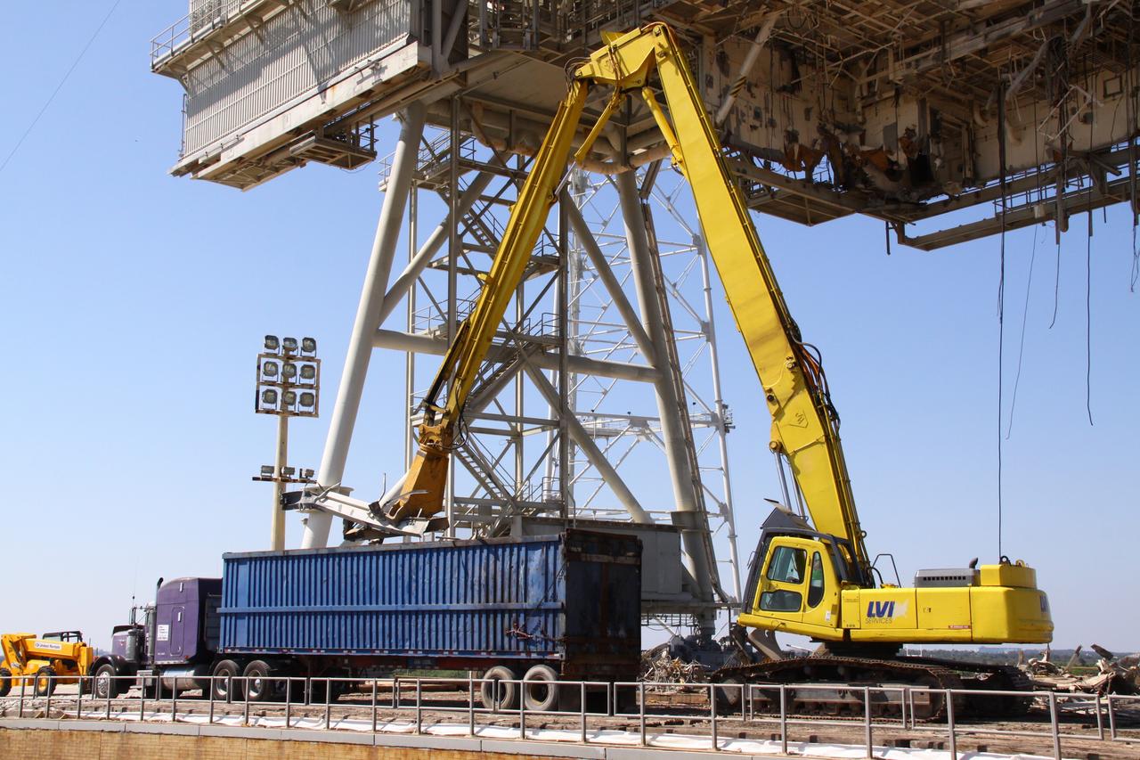CAPE CANAVERAL, Fla. -- At NASA's Kennedy Space Center in Florida, crews continue dismantling the rotating service structure (RSS) on Launch Pad 39B.         Sand, reinforcing steel and large wooden mats were put down under the RSS to protect the structure's concrete from falling debris during deconstruction. Starting in 2009, the structure at the pad was no longer needed for NASA's Space Shuttle Program, so it is being restructured for future use. The new design will feature a "clean pad" for rockets to come with their own launcher, making it more versatile for a number of vehicles. The new lightning protection system, consisting of three lightning towers and a wire catenary system will remain. Photo credit: NASA/Jack Pfaller