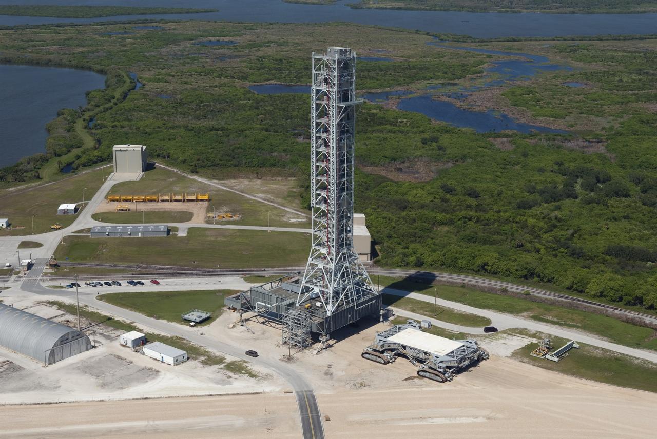 CAPE CANAVERAL, Fla. -- At NASA's Kennedy Space Center in Florida, this view of a crawler-transporter after moving NASA's new mobile launcher (ML) support structure from a construction site, north of the Vehicle Assembly Building (VAB), to the Mobile Launcher east park site is taken from the roof of the VAB. The base of the launcher is lighter than space shuttle mobile launcher platforms so the crawler-transporter can pick up the heavier load of the tower and a taller rocket. Once there, the ML can be outfitted with ground support equipment, such as umbilicals and access arms, for future rocket launches. It took about two years to construct the 355-foot-tall structure, which will support NASA's future human spaceflight program. Photo credit: NASA/Jim Grossmann