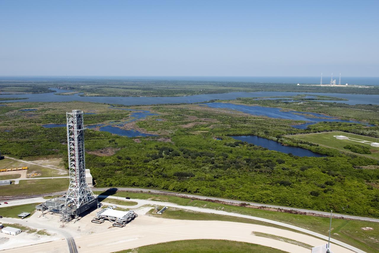 CAPE CANAVERAL, Fla. -- At NASA's Kennedy Space Center in Florida, this view of a crawler-transporter after moving NASA's new mobile launcher (ML) support structure from a construction site, north of the Vehicle Assembly Building (VAB), to the Mobile Launcher east park site is taken from the roof of the VAB. The base of the launcher is lighter than space shuttle mobile launcher platforms so the crawler-transporter can pick up the heavier load of the tower and a taller rocket. Once there, the ML can be outfitted with ground support equipment, such as umbilicals and access arms, for future rocket launches. It took about two years to construct the 355-foot-tall structure, which will support NASA's future human spaceflight program. Photo credit: NASA/Jim Grossmann