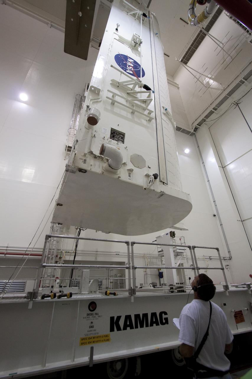 CAPE CANAVERAL, Fla. -- In the Canister Rotation Facility at NASA's Kennedy Space Center in Florida, a workers watches the progress of an overhead crane as it lowers the payload canister onto a transport vehicle.        The canister will then be delivered to Launch Pad 39A, lifted into the rotating service structure where the module will be moved into the clean room before it is installed into space shuttle Discovery's payload bay. Discovery and its STS-133 crew will deliver the PMM, packed with supplies and critical spare parts, as well as Robonaut 2, the dexterous humanoid astronaut helper, to the International Space Station. Launch is targeted for 4:40 p.m. EDT, Nov. 1. Photo credit: NASA/Jack Pfaller