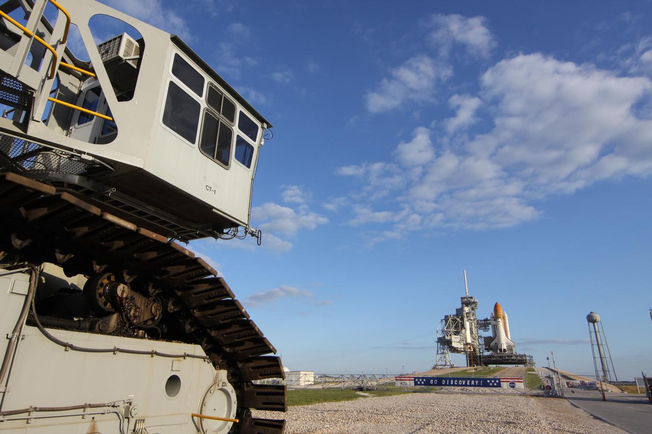 CAPE CANAVERAL, Fla. -- At NASA's Kennedy Space Center in Florida, the STS-133 payload canister now is in the rotating service structure on Launch Pad 39A. A crawler-transporter sits to the left of a sign hanging on the fence in front of the pad entrance supporting space shuttle Discovery.      The payload then will be moved into space shuttle Discovery's payload bay. Discovery and its STS-133 crew will deliver the Permanent Multipurpose Module, packed with supplies and critical spare parts, as well as Robonaut 2, the dexterous humanoid astronaut helper, to the International Space Station. Launch is targeted for 4:40 p.m. EDT, Nov. 1. Photo credit: NASA/Troy Cryder
