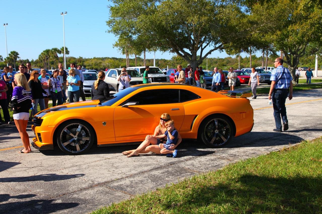 CAPE CANAVERAL, Fla. -- NASA Kennedy Space Center employees in Florida were provided a unique photo opportunity on Oct. 8 from some of the robot 'stars' of the upcoming movie, "Transformers 3." Paramount Pictures filmed scenes for the movie at Kennedy from Oct. 4 through 8. As a show of appreciation for sharing the space center with the "Transformers 3" cast and crew, Kennedy employees and their families were invited to see two Transformers characters, Optimus Prime and Bumblebee, in their vehicle form, on display outside Kennedy Space Center Visitor Complex. In this image Kennedy employee family members pose for a photo in front of 'Bumblebee.' "Transformers 3" is due out in theaters summer 2011. Photo credit: NASA/Frank Michaux