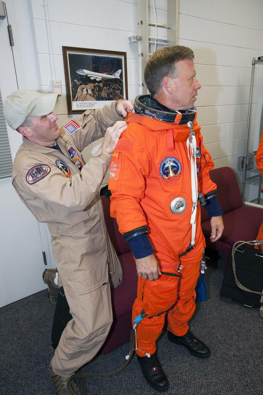 CAPE CANAVERAL, Fla. -- At NASA's Kennedy Space Center in Florida, STS-133 Commander Steve Lindsey puts on his orange flight suit in the Shuttle Landing Facility's Landing Aids Control Building, which is on the south end of the facility's runway. Lindsey and Pilot Eric Boe are preparing to practice landings in Shuttle Training Aircraft, modified Gulfstream II business jets that mimic the shuttle's handling during the final phase of landing. Practice landings are part of the Terminal Countdown Demonstration Test (TCDT), which provides each shuttle crew and launch team an opportunity to participate in various simulated activities, including equipment familiarization and emergency training at the launch pad.    Space shuttle Discovery and its STS-133 crew will deliver the Permanent Multipurpose Module, packed with supplies and critical spare parts, as well as Robonaut 2, the dexterous humanoid astronaut helper, to the International Space Station. Launch is targeted for Nov. 1 at 4:40 p.m. For more information on the STS-133 mission, visit www.nasa.gov/mission_pages/shuttle/shuttlemissions/sts133/. Photo credit: NASA/Jack Pfaller