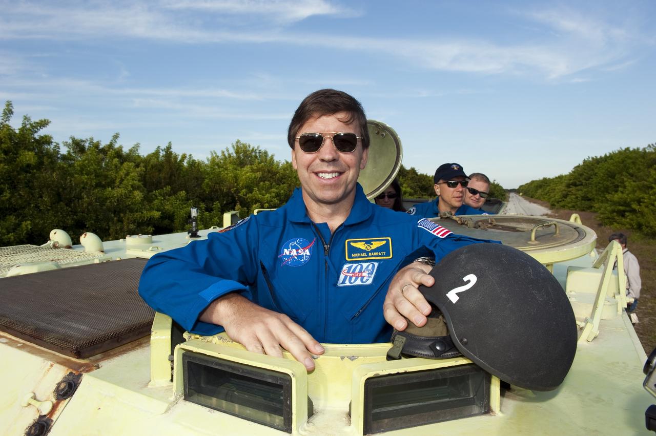CAPE CANAVERAL, Fla. -- At NASA's Kennedy Space Center in Florida, STS-133 Mission Specialist Michael Barratt prepares to practice driving an M-113 armored personnel carrier. Behind him are Mission Specialist Tim Kopra and Pilot Eric Boe. An M-113 is kept at the foot of the launch pad in case an emergency egress from the vicinity of the pad is needed, and training on the vehicle is part of the Terminal Countdown Demonstration Test (TCDT). TCDT provides each shuttle crew and launch team an opportunity to participate in various simulated activities, including equipment familiarization and a launch countdown.    Space shuttle Discovery and its STS-133 crew will deliver the Permanent Multipurpose Module, packed with supplies and critical spare parts, as well as Robonaut 2, the dexterous humanoid astronaut helper, to the International Space Station. Launch is targeted for Nov. 1 at 4:40 p.m. For more information on the STS-133 mission, visit www.nasa.gov/mission_pages/shuttle/shuttlemissions/sts133/. Photo credit: NASA/Kim Shiflett