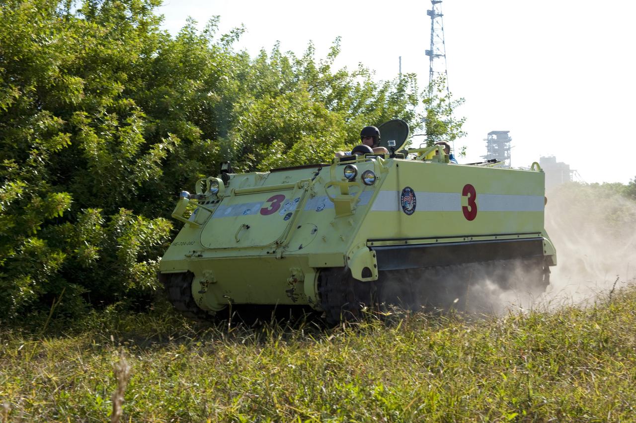 CAPE CANAVERAL, Fla. -- At NASA's Kennedy Space Center in Florida, the crew members of space shuttle Discovery's STS-133 mission go for a ride in an M-113 armored personnel carrier with Battalion Chief David Seymour. An M-113 is kept at the foot of the launch pad in case an emergency egress from the vicinity of the pad is needed, and training on the vehicle is part of the Terminal Countdown Demonstration Test (TCDT). TCDT provides each shuttle crew and launch team an opportunity to participate in various simulated activities, including equipment familiarization and a launch countdown.    Space shuttle Discovery and its STS-133 crew will deliver the Permanent Multipurpose Module, packed with supplies and critical spare parts, as well as Robonaut 2, the dexterous humanoid astronaut helper, to the International Space Station. Launch is targeted for Nov. 1 at 4:40 p.m. For more information on the STS-133 mission, visit www.nasa.gov/mission_pages/shuttle/shuttlemissions/sts133/. Photo credit: NASA/Kim Shiflett