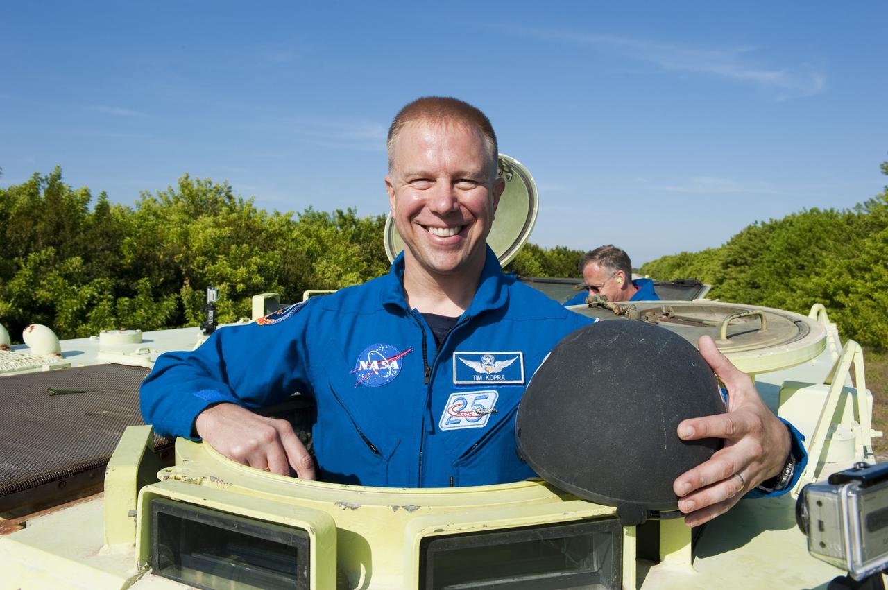 CAPE CANAVERAL, Fla. -- At NASA's Kennedy Space Center in Florida, STS-133 Mission Specialist Tim Kopra prepares to practice driving an M-113 armored personnel carrier. Behind him is Commander Steve Lindsey. An M-113 is kept at the foot of the launch pad in case an emergency egress from the vicinity of the pad is needed, and training on the vehicle is part of the Terminal Countdown Demonstration Test (TCDT). TCDT provides each shuttle crew and launch team an opportunity to participate in various simulated activities, including equipment familiarization and a launch countdown.    Space shuttle Discovery and its STS-133 crew will deliver the Permanent Multipurpose Module, packed with supplies and critical spare parts, as well as Robonaut 2, the dexterous humanoid astronaut helper, to the International Space Station. Launch is targeted for Nov. 1 at 4:40 p.m. For more information on the STS-133 mission, visit www.nasa.gov/mission_pages/shuttle/shuttlemissions/sts133/. Photo credit: NASA/Kim Shiflett