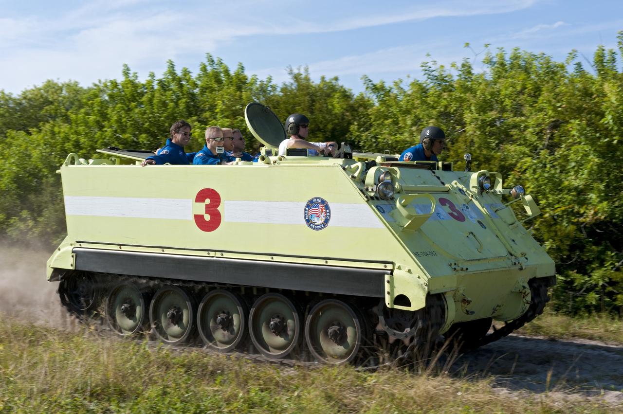 CAPE CANAVERAL, Fla. -- At NASA's Kennedy Space Center in Florida, the crew members of space shuttle Discovery's STS-133 mission go for a ride in an M-113 armored personnel carrier with Battalion Chief David Seymour. An M-113 is kept at the foot of the launch pad in case an emergency egress from the vicinity of the pad is needed, and training on the vehicle is part of the Terminal Countdown Demonstration Test (TCDT). TCDT provides each shuttle crew and launch team an opportunity to participate in various simulated activities, including equipment familiarization and a launch countdown.    Space shuttle Discovery and its STS-133 crew will deliver the Permanent Multipurpose Module, packed with supplies and critical spare parts, as well as Robonaut 2, the dexterous humanoid astronaut helper, to the International Space Station. Launch is targeted for Nov. 1 at 4:40 p.m. For more information on the STS-133 mission, visit www.nasa.gov/mission_pages/shuttle/shuttlemissions/sts133/. Photo credit: NASA/Kim Shiflett