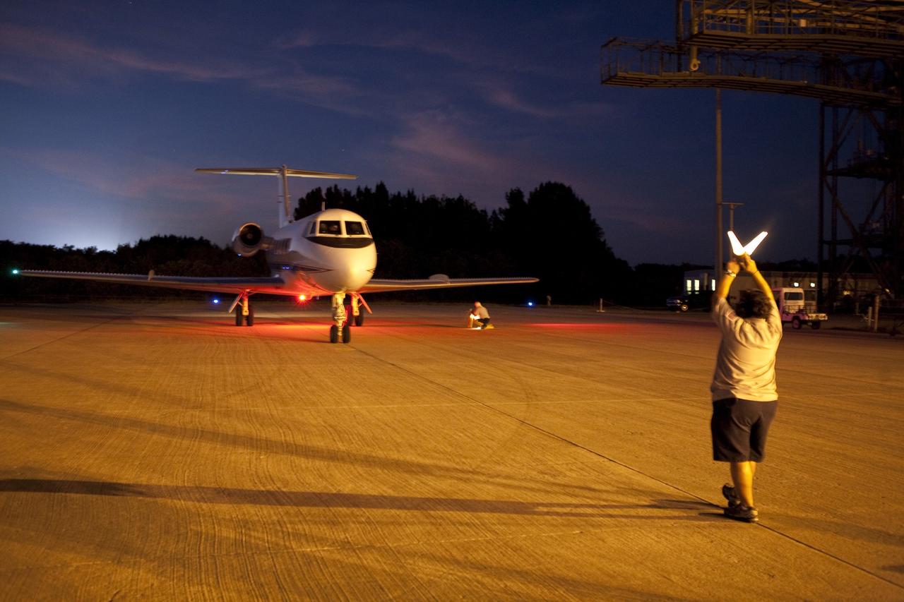 CAPE CANAVERAL, Fla. -- An aircraft servicer marshals a Shuttle Training Aircraft (STA) on the Shuttle Landing Facility runway at NASA's Kennedy Space Center in Florida. STS-133 Commander Steve Lindsey and Pilot Eric Boe flew two Gulfstream II business jets that are modified to mimic the shuttle's handling during the final phase of landing. Practice landings are part of the Terminal Countdown Demonstration Test (TCDT), which provides each shuttle crew and launch team an opportunity to participate in various simulated activities, including equipment familiarization and emergency training at the launch pad.        Space shuttle Discovery and its STS-133 crew will deliver the Permanent Multipurpose Module, packed with supplies and critical spare parts, as well as Robonaut 2, the dexterous humanoid astronaut helper, to the International Space Station. Launch is targeted for Nov. 1 at 4:40 p.m. For more information on the STS-133 mission, visit www.nasa.gov/mission_pages/shuttle/shuttlemissions/sts133/. Photo credit: NASA/Amanda Diller