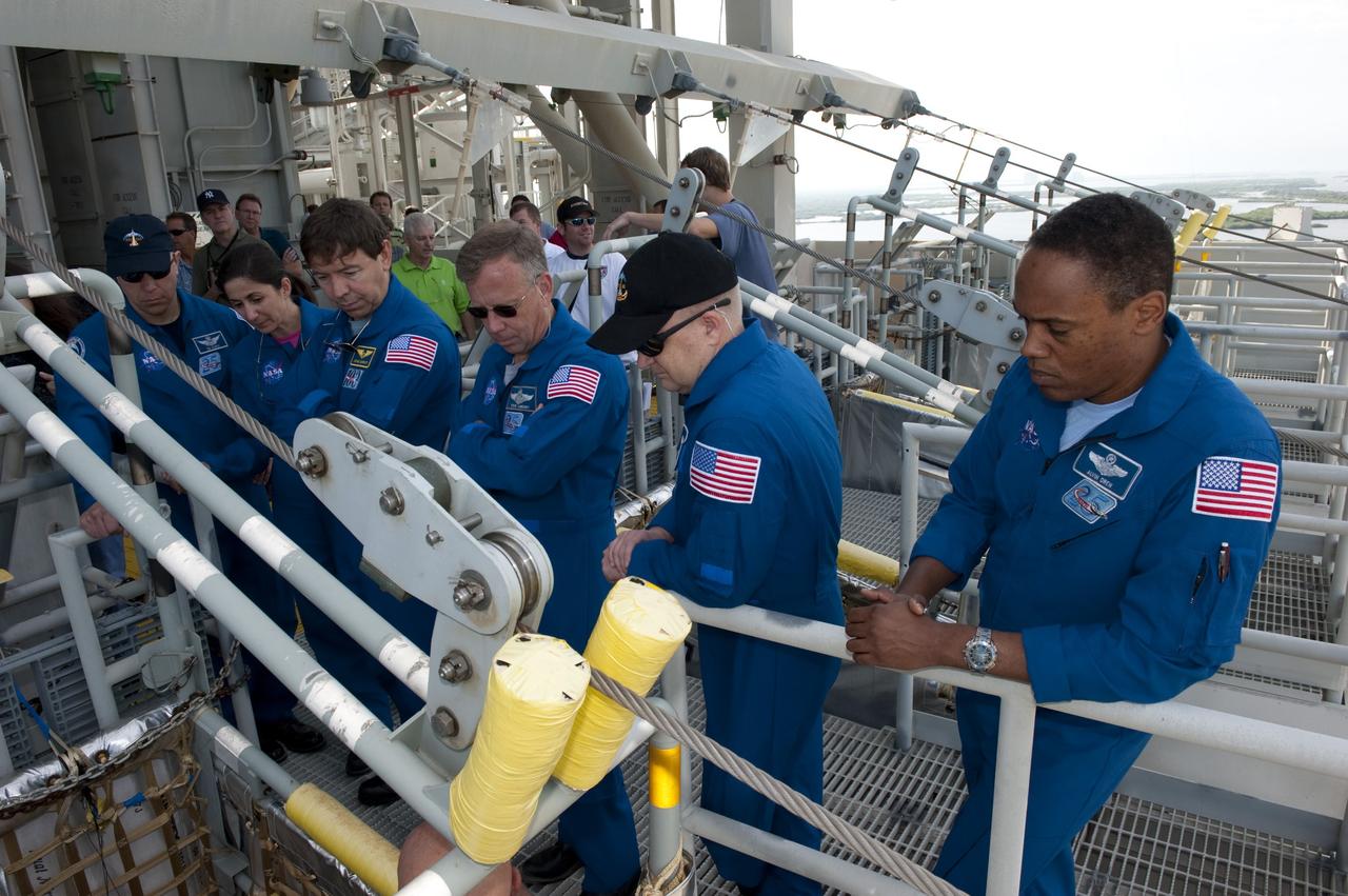 CAPE CANAVERAL, Fla. -- On Launch Pad 39A at NASA's Kennedy Space Center, the members of the STS-133 crew receive instruction on the operation of the pad's slidewire basket system emergency exit training as part of the Terminal Countdown Demonstration Test (TCDT). Pictured are Mission Specialist Alvin Drew (right); Pilot Eric Boe; Commander Steve Lindsey; Mission Specialists Michael Barratt, Nicole Stott and Tim Kopra.              TCDT provides each shuttle crew and launch team an opportunity to participate in various simulated activities, including equipment familiarization and a launch countdown. Space shuttle Discovery and its STS-133 crew will deliver the Permanent Multipurpose Module, packed with supplies and critical spare parts, as well as Robonaut 2, the dexterous humanoid astronaut helper, to the International Space Station. Launch is targeted for Nov. 1 at 4:40 p.m. For more information on the STS-133 mission, visit www.nasa.gov/mission_pages/shuttle/shuttlemissions/sts133/. Photo credit: NASA/Kim Shiflett