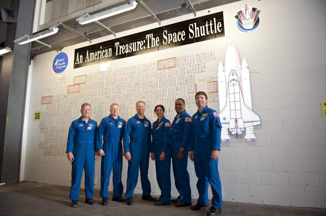 CAPE CANAVERAL, Fla. -- At NASA's Kennedy Space Center in Florida, STS-133 crew members pose in front of the space shuttle wall tribute in the Vehicle Assembly Building. Kennedy employees who have supported the Space Shuttle Program throughout the last 30 years have been signing the wall as a tribute to the program. From left are Commander Steve Lindsey, Pilot Eric Boe, and Mission Specialists Tim Kopra, Nicole Stott, Alvin Drew, and Michael Barratt.    TCDT provides each shuttle crew and launch team an opportunity to participate in various simulated activities, including equipment familiarization and a launch countdown. Space shuttle Discovery and its STS-133 crew will deliver the Permanent Multipurpose Module, packed with supplies and critical spare parts, as well as Robonaut 2, the dexterous humanoid astronaut helper, to the International Space Station. Launch is targeted for Nov. 1 at 4:40 p.m. For more information on the STS-133 mission, visit www.nasa.gov/mission_pages/shuttle/shuttlemissions/sts133/. Photo credit: NASA/Kim Shiflett