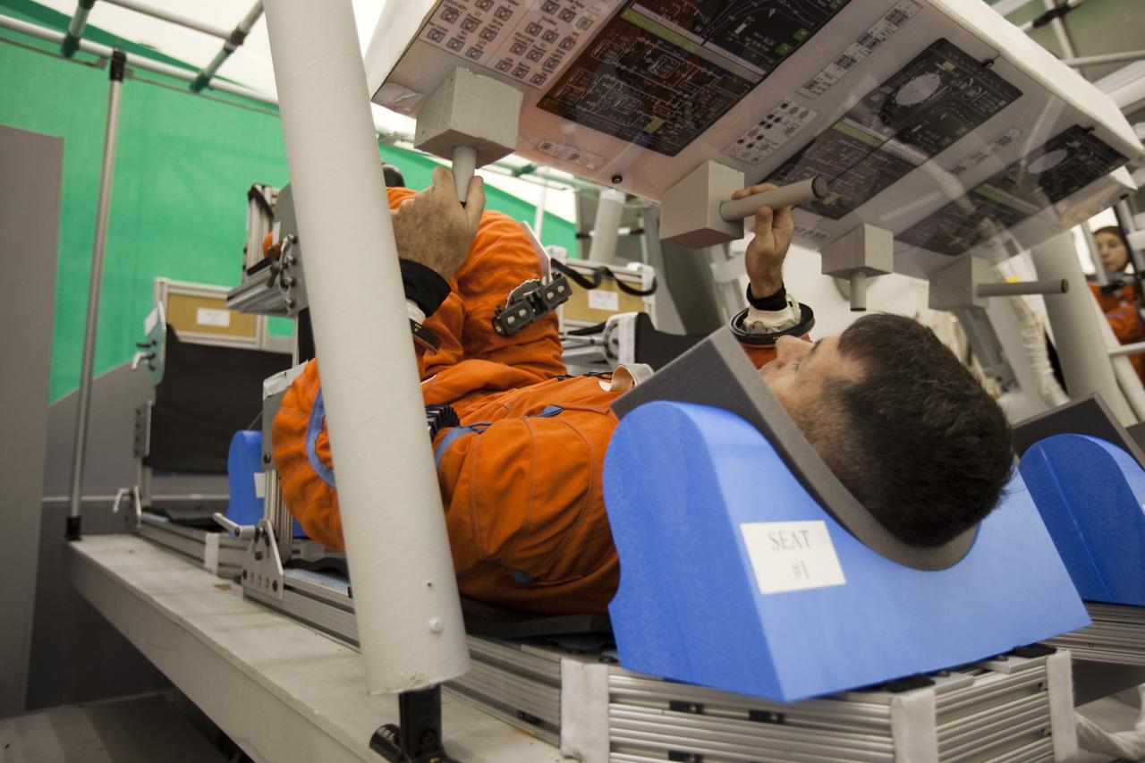 CAPE CANAVERAL, Fla. -- In the Multi-Payload Processing Facility at NASA's Kennedy Space Center in Florida, NASA astronaut Shane Kimbrough participates in an exercise known as crew egress evaluation from an Orion mock-up. The spacecraft is replicated in all areas that could affect a crew's escape, including the area that seals to a launch pad's White Room. The exercise focuses on whether astronauts and their rescue crews can exit the vehicle quickly in the event of a pad emergency.       For more information on Orion, visit www.nasa.gov/orion. Photo credit: NASA/Dimitri Gerondidakis