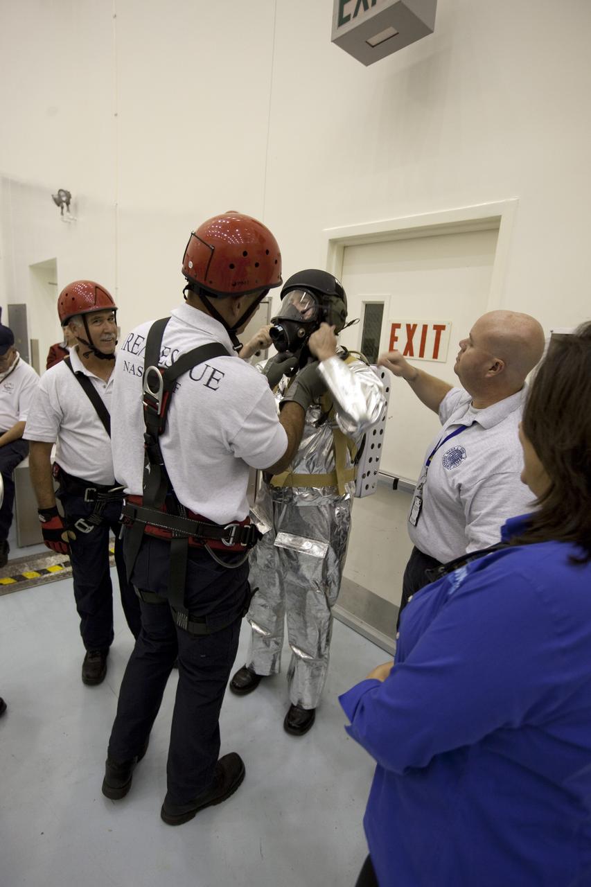 CAPE CANAVERAL, Fla. -- In the Multi-Payload Processing Facility at NASA's Kennedy Space Center in Florida, fire and rescue personnel, as well as a closeout crew, participate in an exercise known as crew egress evaluation from an Orion mock-up. The spacecraft is replicated in all areas that could affect a crew's escape, including the area that seals to a launch pad's White Room. The exercise focuses on whether astronauts and their rescue crews can exit the vehicle quickly in the event of a pad emergency.       For more information on Orion, visit www.nasa.gov/orion. Photo credit: NASA/Dimitri Gerondidakis