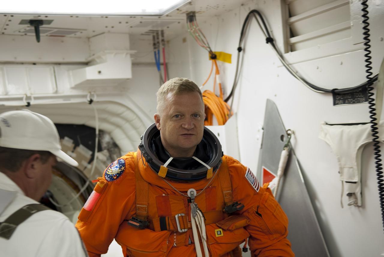 CAPE CANAVERAL, Fla. -- In the White Room of Launch Pad 39A at NASA's Kennedy Space Center in Florida, STS-133 Pilot Eric Boe prepares to board space shuttle Discovery during the Terminal Countdown Demonstration Test (TCDT). Part of TCDT includes practicing the final hours of a real launch day when astronauts put on their launch-and-entry suits, ride to the pad in the Astrovan and strap into the shuttle.    Discovery and its STS-133 crew will deliver the Permanent Multipurpose Module, packed with supplies and critical spare parts, as well as Robonaut 2, the dexterous humanoid astronaut helper, to the International Space Station. Launch is targeted for Nov. 1 at 4:40 p.m. For more information on the STS-133 mission, visit www.nasa.gov/mission_pages/shuttle/shuttlemissions/sts133/. Photo credit: NASA/Jim Grossmann