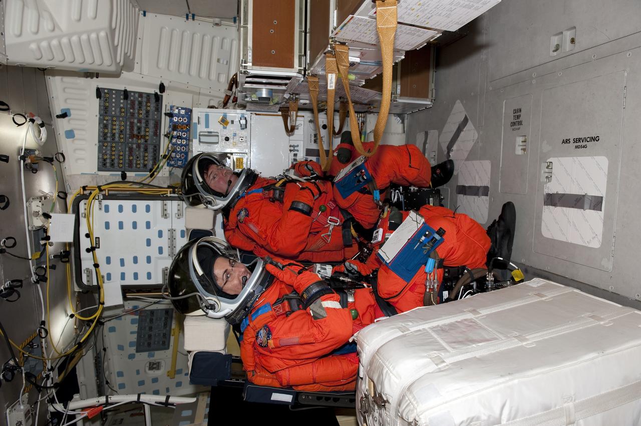 CAPE CANAVERAL, Fla. -- During a simulated launch countdown on Launch Pad 39A at NASA's Kennedy Space Center in Florida, STS-133 Mission Specialists Nicole Stott, left, and Michael Barratt are strapped into their seats on space shuttle Discovery. Next, they will practice escaping the shuttle, in preparation for an unlikely emergency at the pad on launch day. The simulated launch countdown and emergency exit training are part of a week-long Terminal Countdown Demonstration Test (TCDT). Discovery and its STS-133 crew will deliver the Permanent Multipurpose Module, packed with supplies and critical spare parts, as well as Robonaut 2, the dexterous humanoid astronaut helper, to the International Space Station. Launch is targeted for Nov. 1 at 4:40 p.m. For more information on the STS-133 mission, visit www.nasa.gov/mission_pages/shuttle/shuttlemissions/sts133/. Photo credit: NASA/Kim Shiflett