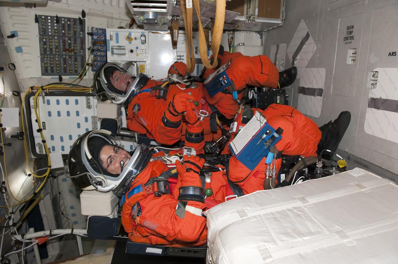 CAPE CANAVERAL, Fla. -- During a simulated launch countdown on Launch Pad 39A at NASA's Kennedy Space Center in Florida, STS-133 Mission Specialists Nicole Stott, left, and Michael Barratt are strapped into their seats on space shuttle Discovery. Next, they will practice escaping the shuttle, in preparation for an unlikely emergency at the pad on launch day. The simulated launch countdown and emergency exit training are part of a week-long Terminal Countdown Demonstration Test (TCDT).        Discovery and its STS-133 crew will deliver the Permanent Multipurpose Module, packed with supplies and critical spare parts, as well as Robonaut 2, the dexterous humanoid astronaut helper, to the International Space Station. Launch is targeted for Nov. 1 at 4:40 p.m. For more information on the STS-133 mission, visit www.nasa.gov/mission_pages/shuttle/shuttlemissions/sts133/. Photo credit: NASA/Kim Shiflett