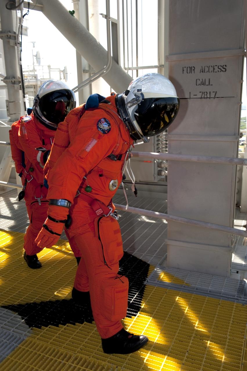 CAPE CANAVERAL, Fla. -- During a simulated pad emergency on Launch Pad 39A at NASA's Kennedy Space Center in Florida, STS-133 Mission Specialists Michael Barratt, left, and Nicole Stott make their way toward a slidewire basket that would take them to a safe bunker below the pad in an unlikely emergency situation. The emergency training while aboard space shuttle Discovery is part of a week-long Terminal Countdown Demonstration Test (TCDT). Discovery and its STS-133 crew will deliver the Permanent Multipurpose Module, packed with supplies and critical spare parts, as well as Robonaut 2, the dexterous humanoid astronaut helper, to the International Space Station. Launch is targeted for Nov. 1 at 4:40 p.m. For more information on the STS-133 mission, visit www.nasa.gov/mission_pages/shuttle/shuttlemissions/sts133/. Photo credit: NASA/Kim Shiflett