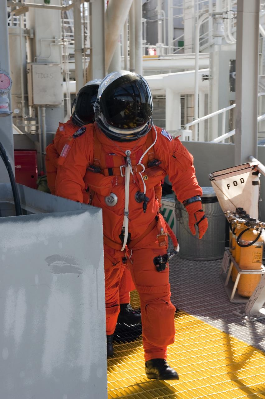 CAPE CANAVERAL, Fla. -- During a simulated pad emergency on Launch Pad 39A at NASA's Kennedy Space Center in Florida, STS-133 Pilot Eric Boe, left, and Commander Steve Lindsey make their way toward a slidewire basket that would take them to a safe bunker below the pad in an unlikely emergency situation. The emergency training while aboard space shuttle Discovery is part of a week-long Terminal Countdown Demonstration Test (TCDT). Discovery and its STS-133 crew will deliver the Permanent Multipurpose Module, packed with supplies and critical spare parts, as well as Robonaut 2, the dexterous humanoid astronaut helper, to the International Space Station. Launch is targeted for Nov. 1 at 4:40 p.m. For more information on the STS-133 mission, visit www.nasa.gov/mission_pages/shuttle/shuttlemissions/sts133/. Photo credit: NASA/Kim Shiflett