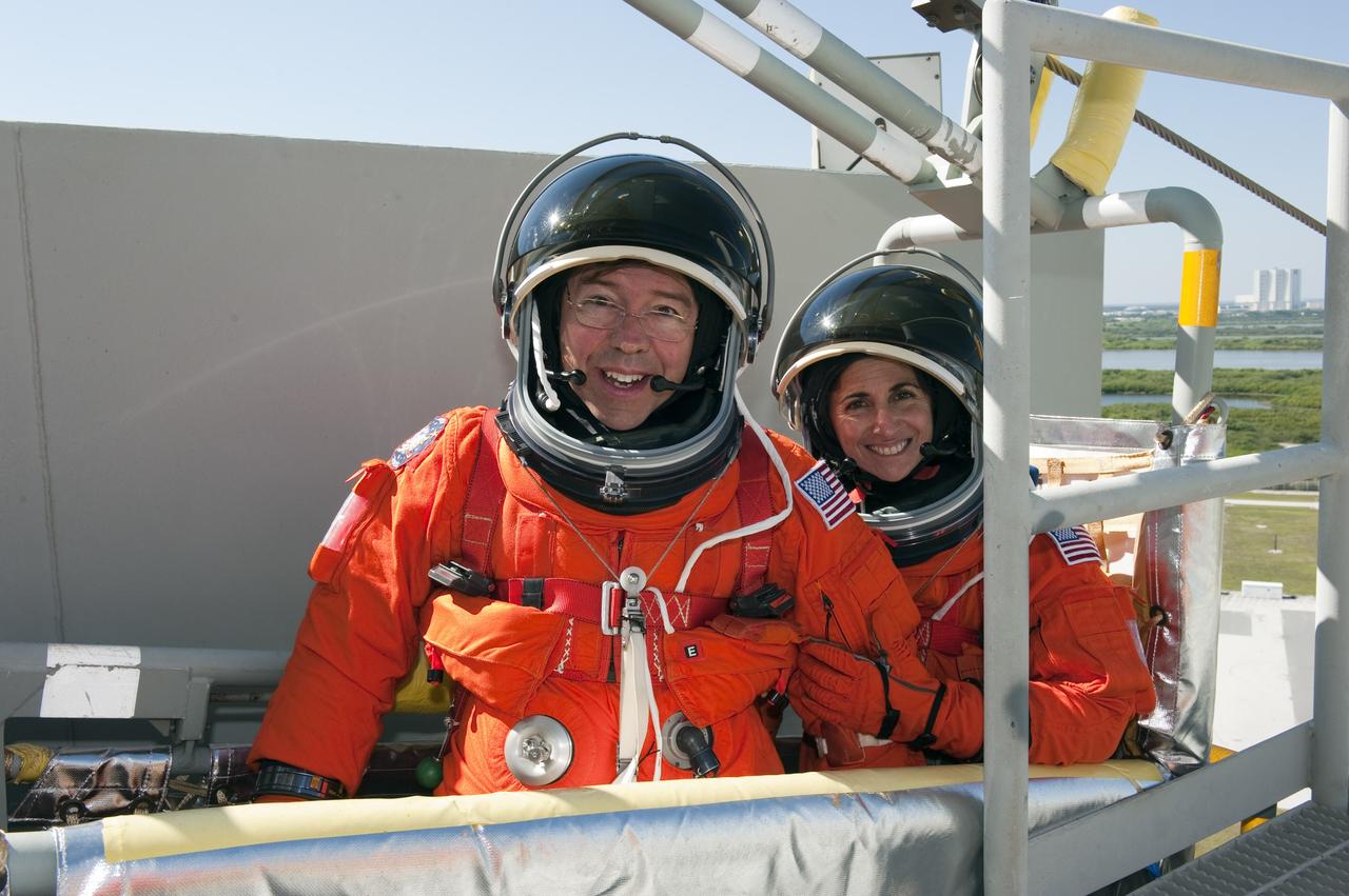 CAPE CANAVERAL, Fla. -- During a simulated pad emergency on Launch Pad 39A at NASA's Kennedy Space Center in Florida, STS-133 Mission Specialists Michael Barratt, front left, and Nicole Stott hop in a slidewire basket that would take them to a safe bunker below the pad in an unlikely emergency situation. The emergency training while aboard space shuttle Discovery is part of a week-long Terminal Countdown Demonstration Test (TCDT).    Discovery and its STS-133 crew will deliver the Permanent Multipurpose Module, packed with supplies and critical spare parts, as well as Robonaut 2, the dexterous humanoid astronaut helper, to the International Space Station. Launch is targeted for Nov. 1 at 4:40 p.m. For more information on the STS-133 mission, visit www.nasa.gov/mission_pages/shuttle/shuttlemissions/sts133/. Photo credit: NASA/Kim Shiflett