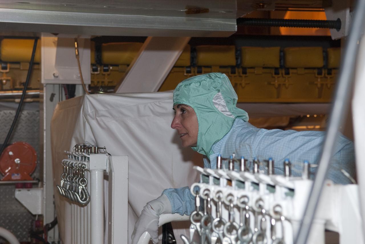 CAPE CANAVERAL, Fla. -- At NASA's Kennedy Space Center in Florida, STS-133 Mission Specialist Nicole Stott checks out her mission's payload while at Launch Pad 39A for the Terminal Countdown Demonstration Test (TCDT).     Discovery and its STS-133 crew will deliver the Permanent Multipurpose Module, packed with supplies and critical spare parts, as well as Robonaut 2, the dexterous humanoid astronaut helper, to the International Space Station. Launch is targeted for 4:40 p.m. EDT, Nov. 1. Photo credit: NASA/Jim Grossmann