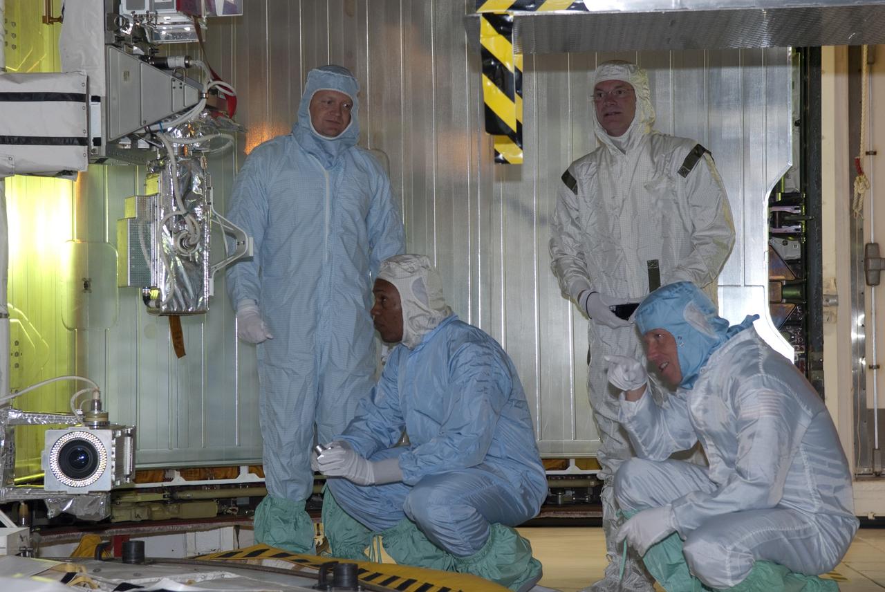 CAPE CANAVERAL, Fla. -- At NASA's Kennedy Space Center in Florida, STS-133 crew members check out their mission's payload while at Launch Pad 39A for the Terminal Countdown Demonstration Test (TCDT). From left, are Pilot Eric Boe, and Mission Specialists Alvin Drew, and Tim Kopra. Standing behind Kopra in a white "bunny suit" is a pad technician. Discovery and its STS-133 crew will deliver the Permanent Multipurpose Module, packed with supplies and critical spare parts, as well as Robonaut 2, the dexterous humanoid astronaut helper, to the International Space Station. Launch is targeted for 4:40 p.m. EDT, Nov. 1. Photo credit: NASA/Jim Grossmann
