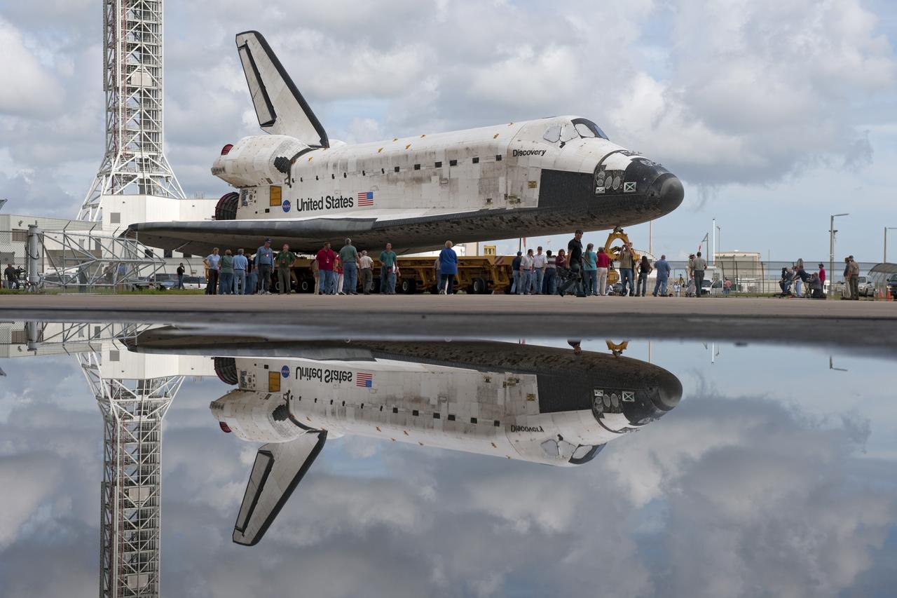 CAPE CANAVERAL, Fla. -- At NASA's Kennedy Space Center in Florida, shuttle Discovery pauses for photos during its move called "rollover" from Orbiter Processing Facility-3 to the nearby Vehicle Assembly Building (VAB). Behind and to the left of Discovery is NASA's new 355-foot-tall mobile launcher support structure. Once inside the VAB, the shuttle will be joined to its solid rocket boosters and external fuel tank. Later, Discovery will "roll out" to Launch Pad 39A for its launch to the International Space Station on the STS-133 mission.     Targeted to liftoff Nov. 1, Discovery will take the Permanent Multipurpose Module (PMM) packed with supplies and critical spare parts, as well as Robonaut 2 (R2) to the station.  Photo credit: NASA/Ben Cooper