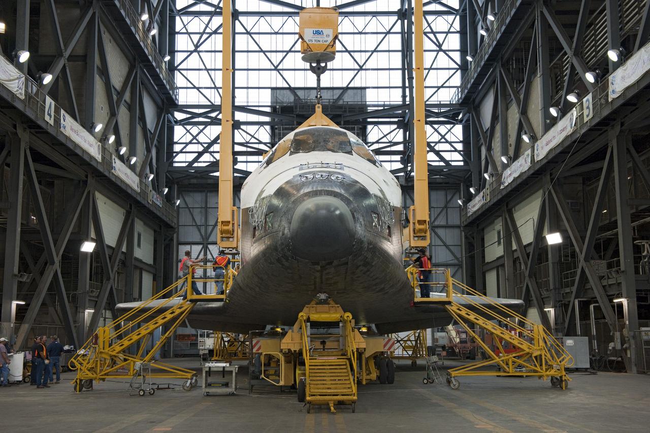 CAPE CANAVERAL, Fla. -- At NASA's Kennedy Space Center in Florida, workers in the Vehicle Assembly Building begin to secure a large yellow, metal sling to shuttle Discovery for its lift from the transfer aisle into High Bay 3. In the bay, the shuttle will be attached to its external fuel tank and solid rocket boosters. The operation began Sept. 9 and wrapped up early Sept. 10. Later, Discovery will "roll out" to Launch Pad 39A in preparation for its launch to the International Space Station on the STS-133 mission. Targeted to liftoff Nov. 1, Discovery will take the Permanent Multipurpose Module (PMM) packed with supplies and critical spare parts, as well as Robonaut 2 (R2) to the station. Photo credit: NASA/Ben Cooper