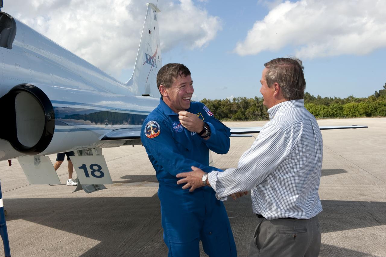 CAPE CANAVERAL, Fla. -- At NASA's Kennedy Space Center in Florida, space shuttle Discovery's STS-133 Mission Specialist Michael Barratt, left, is greeted by Shuttle Launch Director Mike Leinbach on the Shuttle Landing Facility runway after arriving in a T-38 training jet. In the days leading up to their launch to the International Space Station, Barratt and his crew members will check the fit of their launch-and-entry suits, review launch-day procedures, receive weather briefings and remain medically quarantined to prevent sickness.      Scheduled to lift off Nov. 1 at 4:40 p.m., Discovery and crew will deliver the Permanent Multipurpose Module, packed with supplies and critical spare parts, as well as Robonaut 2, the dexterous humanoid astronaut helper, to the orbiting outpost. For more information on the STS-133 mission, visit www.nasa.gov/mission_pages/shuttle/shuttlemissions/sts133/. Photo credit: NASA/Kim Shiflett