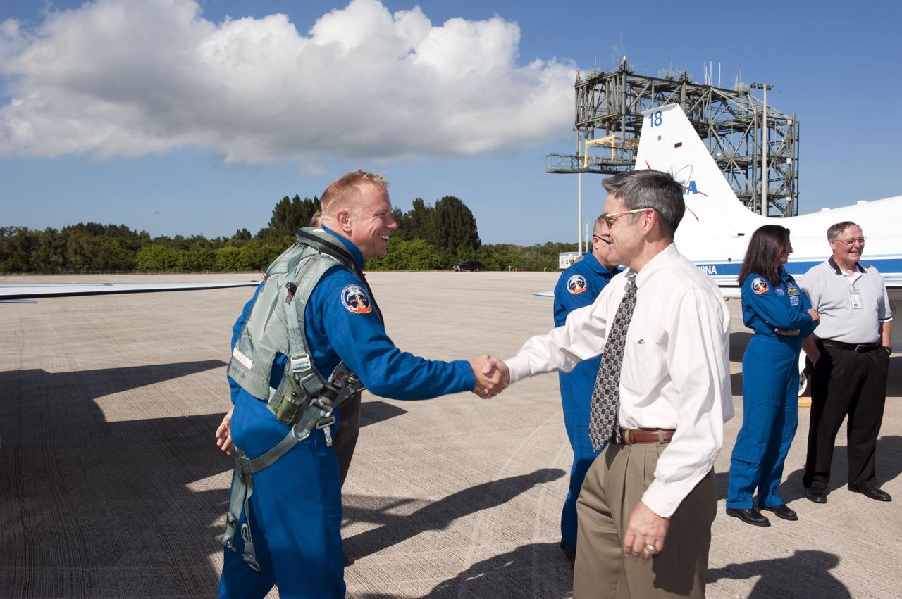 CAPE CANAVERAL, Fla. -- At NASA's Kennedy Space Center in Florida, space shuttle Discovery's STS-133 Mission Specialist Tim Kopra, left, shakes hands with Kennedy's Center Director Bob Cabana on the Shuttle Landing Facility runway after arriving in a T-38 training jet. In the days leading up to their launch to the International Space Station, Kopra and his crew members will check the fit of their launch-and-entry suits, review launch-day procedures, receive weather briefings and remain medically quarantined to prevent sickness.        Scheduled to lift off Nov. 1 at 4:40 p.m., Discovery and crew will deliver the Permanent Multipurpose Module, packed with supplies and critical spare parts, as well as Robonaut 2, the dexterous humanoid astronaut helper, to the orbiting outpost. For more information on the STS-133 mission, visit www.nasa.gov/mission_pages/shuttle/shuttlemissions/sts133/. Photo credit: NASA/Kim Shiflett