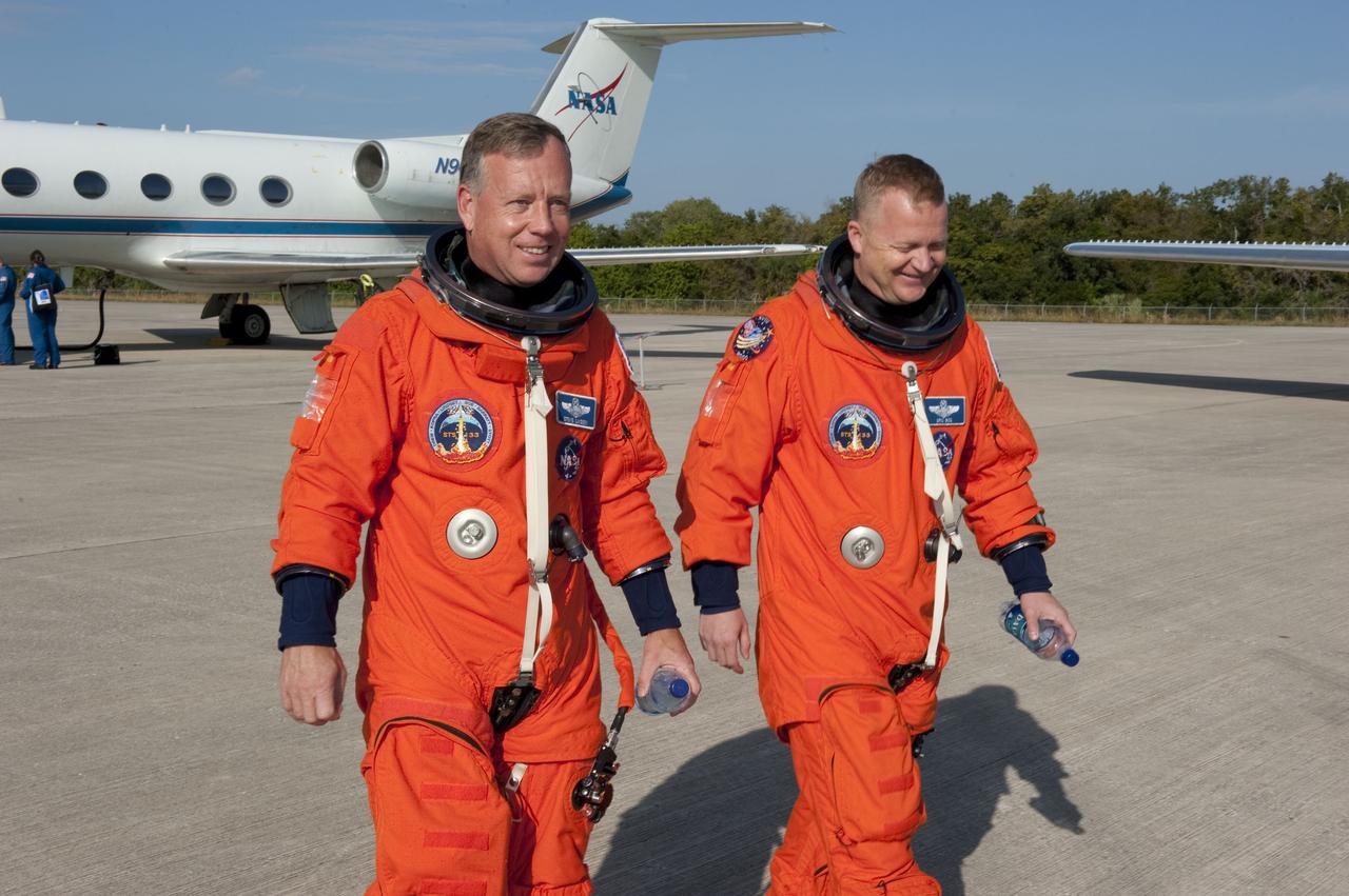 CANAVERAL, Fla. -- At NASA's Kennedy Space Center in Florida, STS-133 Commander Steve Lindsey, left, and Pilot Eric Boe return from flying touch-and-go landings in two Shuttle Training Aircraft (STA) over the Shuttle Landing Facility runway. The Gulfstream II business jets are modified to mimic the shuttle's handling during the final phase of landing.    Space shuttle Discovery's crew members are at Kennedy for their upcoming launch to the International Space Station. In the days leading up to lift off, they will check the fit of their spacesuits, review launch-day procedures, receive weather briefings and remain medically quarantined to prevent sickness. STS-133 will deliver the Permanent Multipurpose Module, packed with supplies and critical spare parts, as well as Robonaut 2, the dexterous humanoid astronaut helper, to the orbiting outpost. For more information on the STS-133 mission, visit www.nasa.gov/mission_pages/shuttle/shuttlemissions/sts133/. Photo credit: NASA/Kim Shiflett
