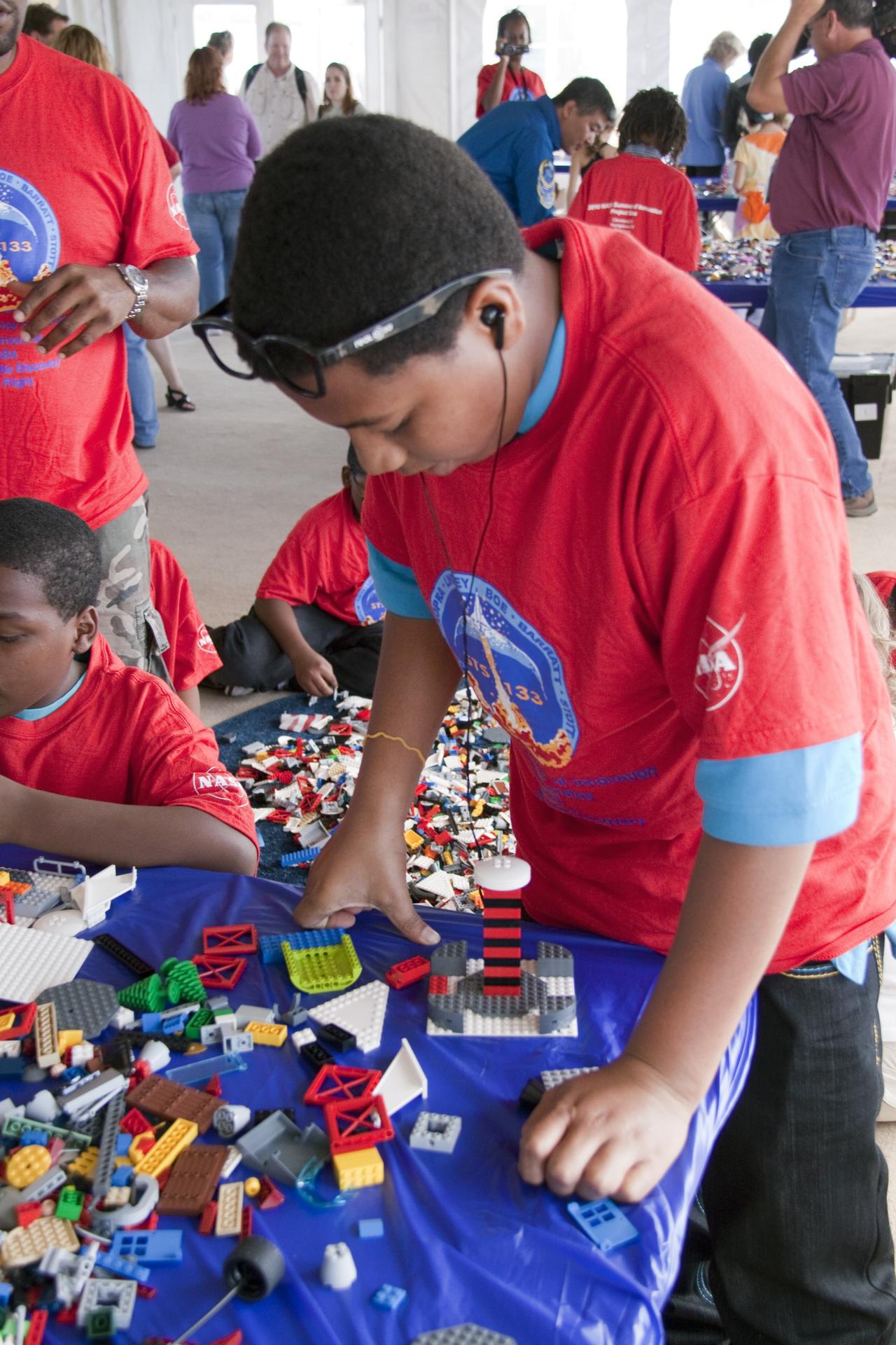 A student in red t-shirt playing with LEGOS