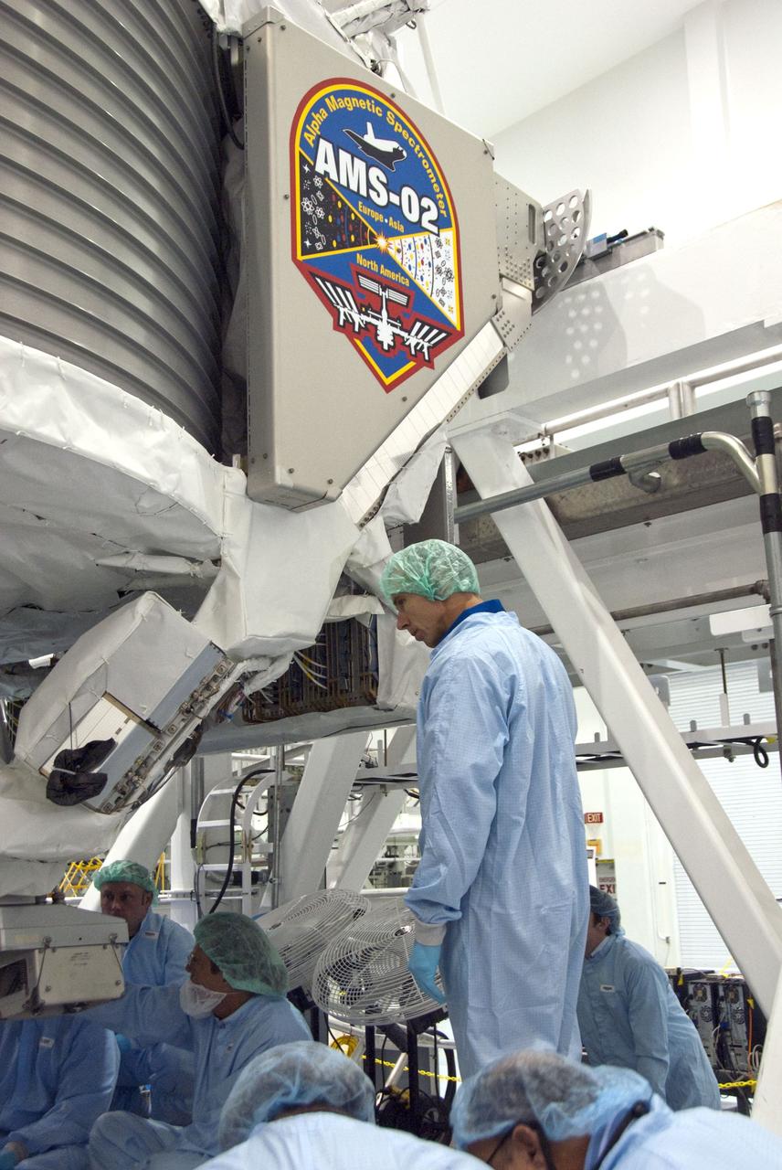 CAPE CANAVERAL, Fla. -- In the Space Station Processing Facility at NASA's Kennedy Space Center in Florida, STS-134 Mission Specialist Roberto Vittori inspects the Alpha Magnetic Spectrometer-2 (AMS) with the experiment's technicians. Vittori, who is with the European Space Agency, and his five crewmates are at Kennedy participating in the Crew Equipment Interface Test (CEIT), which gives them an opportunity for hands-on training with tools they'll be using in space and familiarization of the payload they'll be delivering to the International Space Station.              Space shuttle Endeavour is targeted to launch on the STS-134 mission Feb. 27, 2011. For more information, visit www.nasa.gov/mission_pages/shuttle/shuttlemissions/sts134/index.html. Photo credit: NASA/Cory Huston