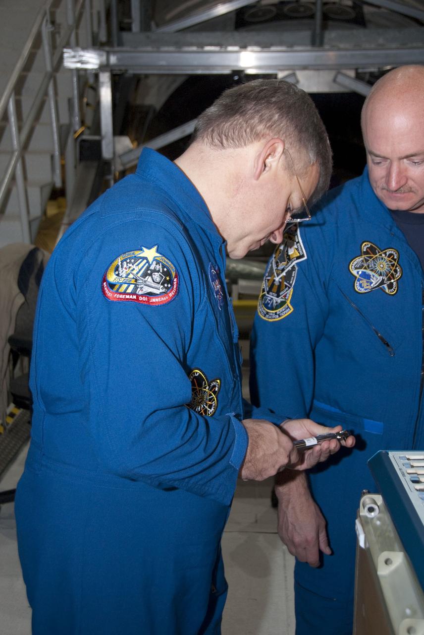 CAPE CANAVERAL, Fla. -- In the Orbiter Processing Facility-2 at NASA's Kennedy Space Center in Florida, STS-134 Pilot Gregory H. Johnson, left, and Commander Mark Kelly check out a tool they'll be using in space. The six STS-134 astronauts are at Kennedy participating in the Crew Equipment Interface Test (CEIT), which gives them an opportunity for hands-on training and familiarization of the payload they'll be delivering to the International Space Station. Space shuttle Endeavour is targeted to launch on the STS-134 mission Feb. 27, 2011. For more information, visit www.nasa.gov/mission_pages/shuttle/shuttlemissions/sts134/index.html. Photo credit: NASA/Cory Huston